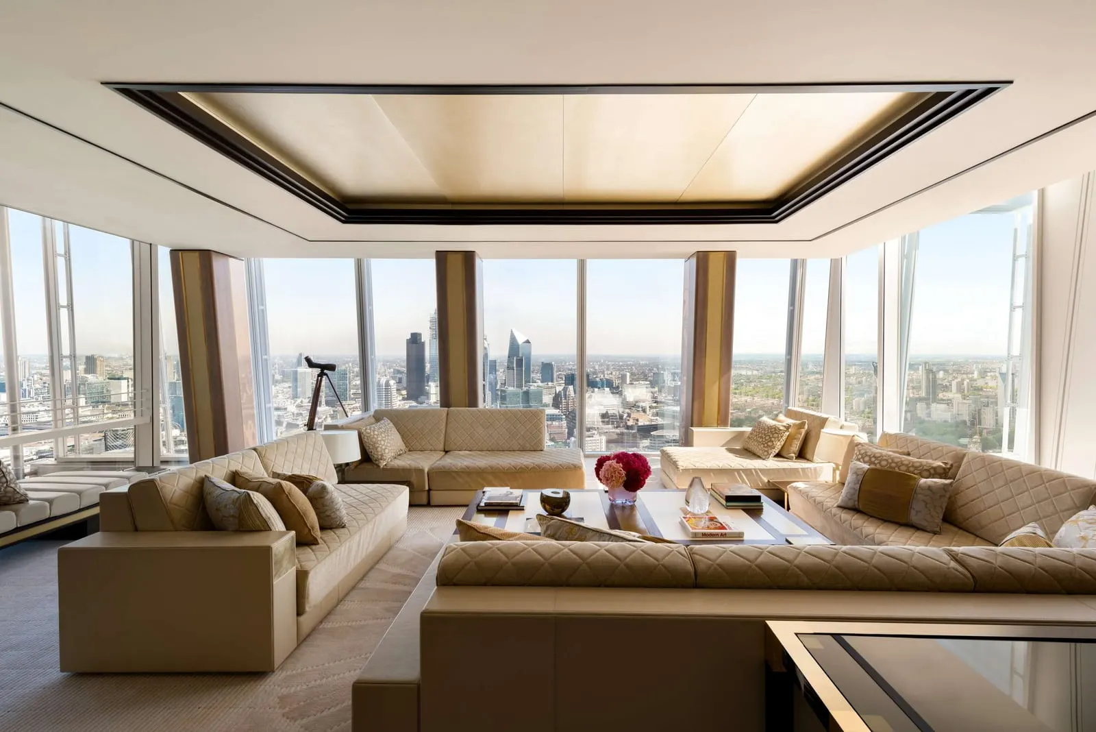 Shangri-La Suite and Premier City View Room Interconnecting: the lounge with sofas, a telescope and City towers beyond
