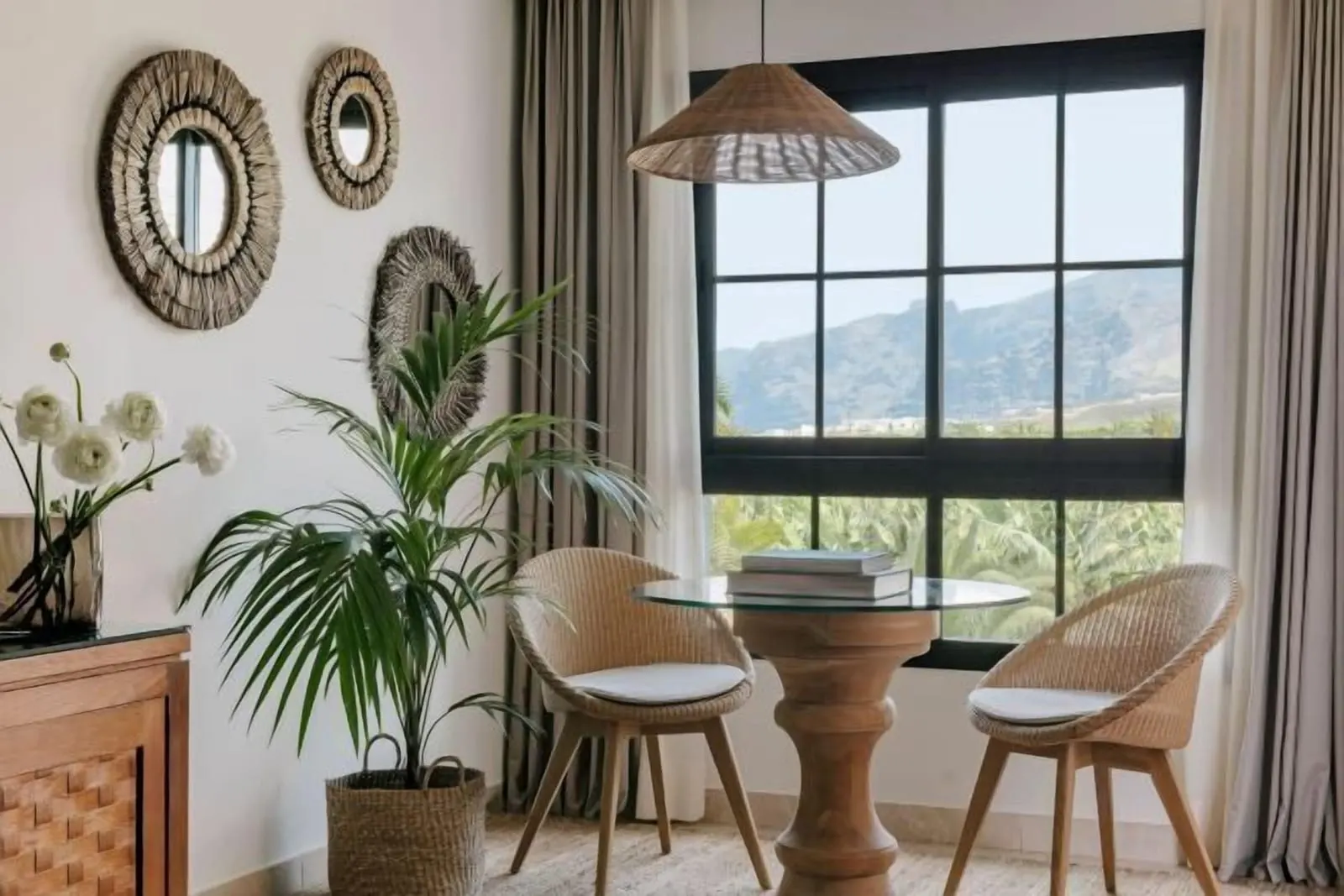 RedLevel Junior Suite at Gran Meliá Palacio de Isora: a table and wicker chairs by a window onto hills