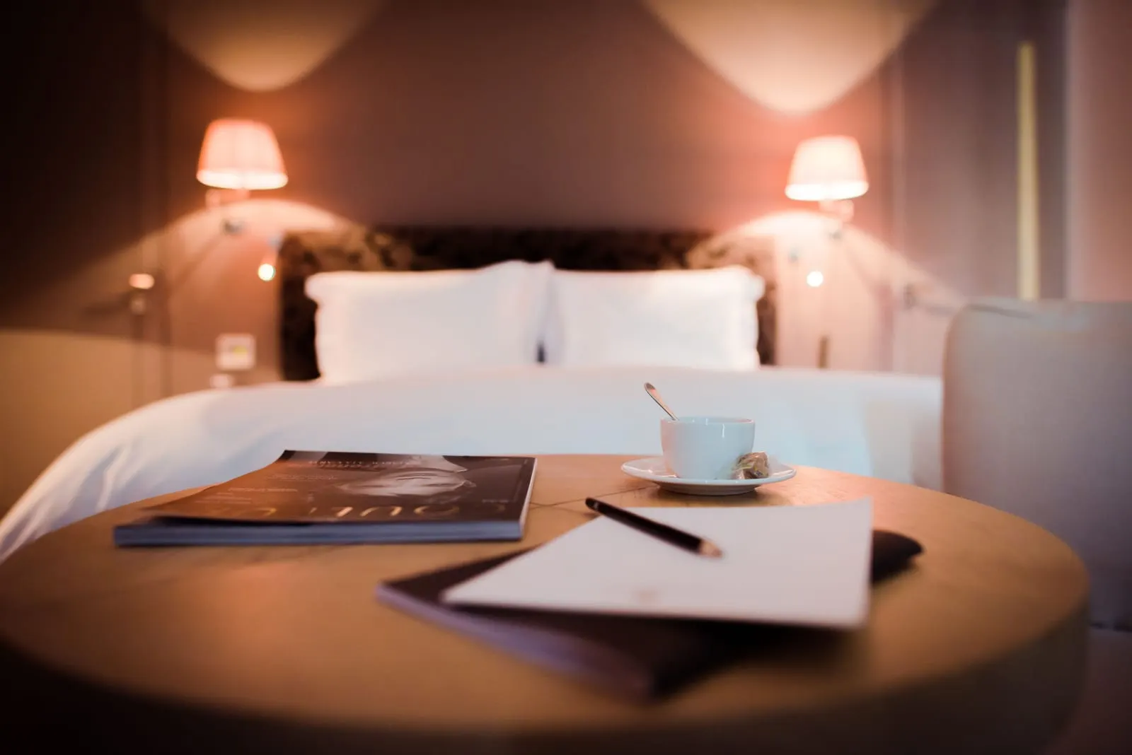 Lounge Suite at Palais Namaskar: a round table with a coffee cup and notepaper at the foot of the bed
