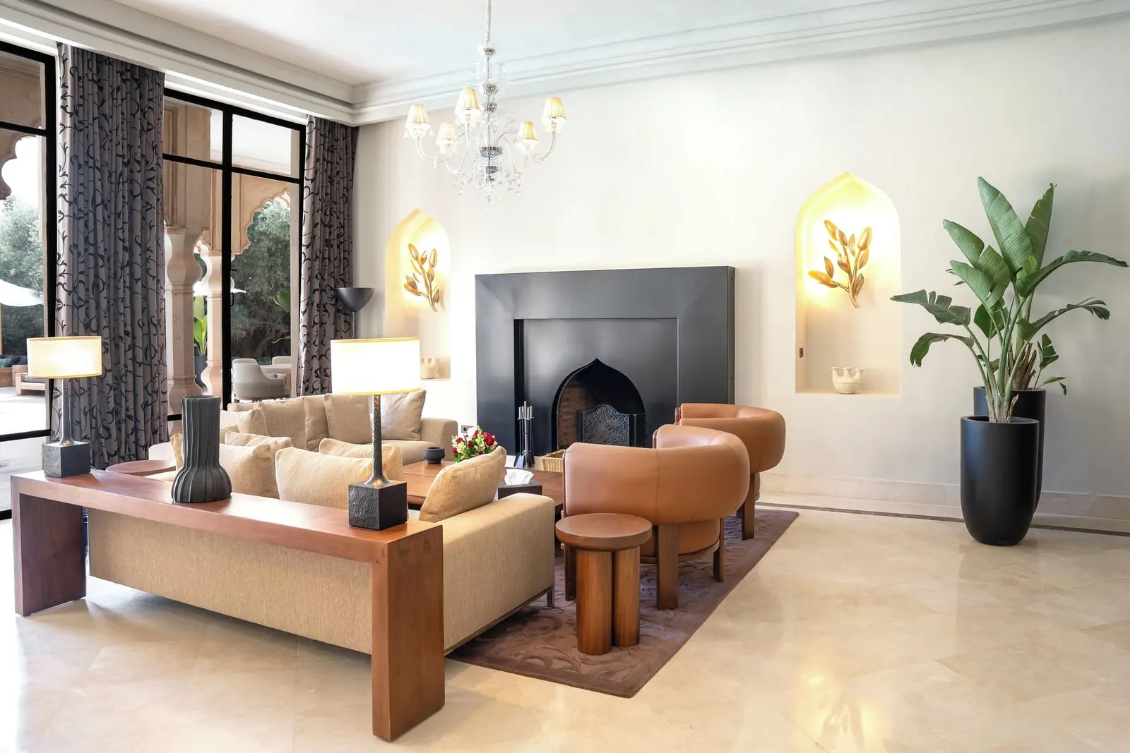 Mountain Palace at Palais Namaskar: a living room with leather armchairs and a sofa around a large black fireplace