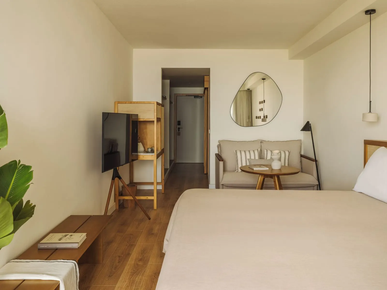 Premium Room Frontal Ocean Horizon at Paradisus by Meliá Fuerteventura: a bed, a two-seat sofa with a round table, and a television on a stand by the entrance hall