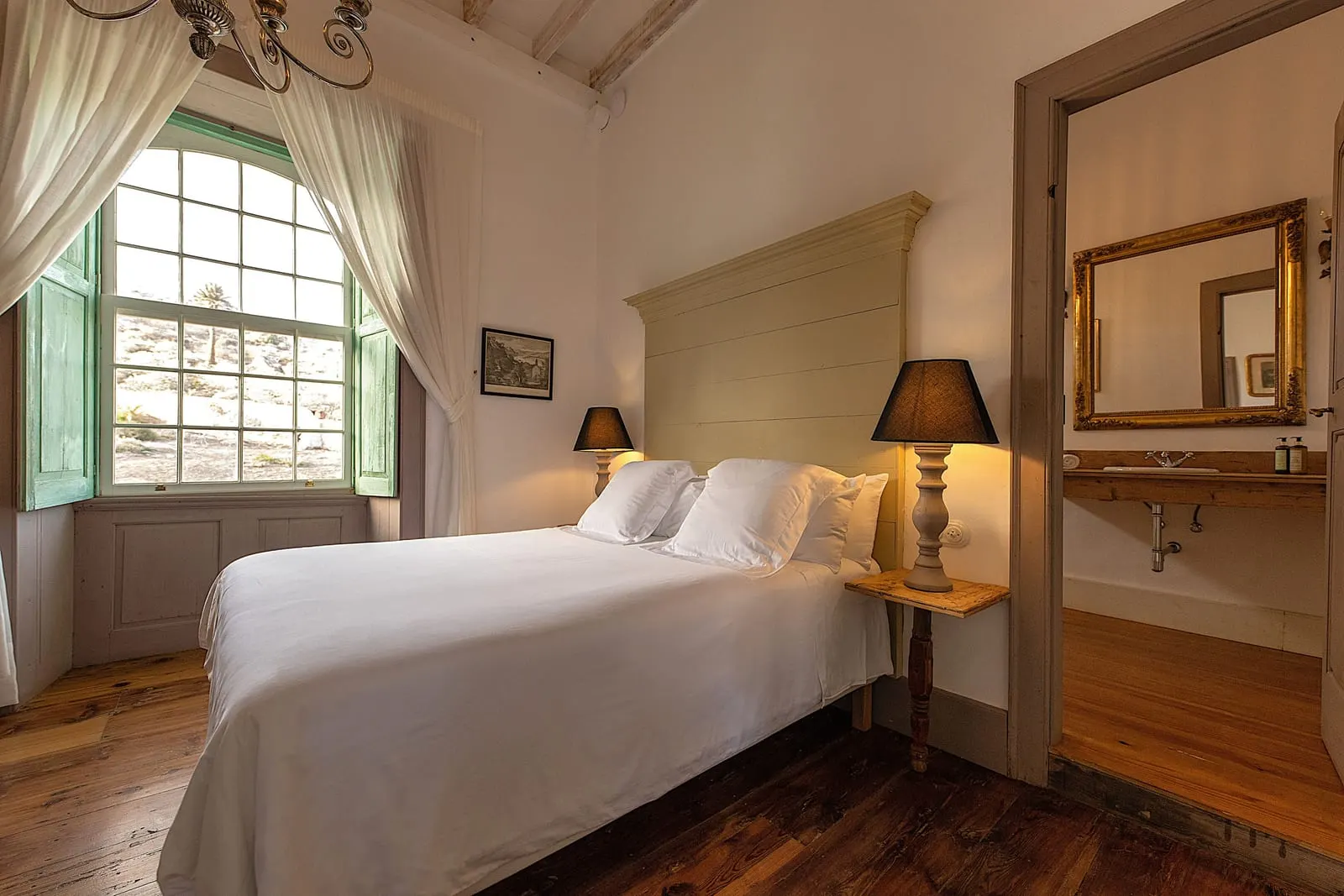 Room Nº7. Double en La Casa de los Naranjos: una cama doble con cabecero claro junto a una ventana alta en arco y un espejo dorado