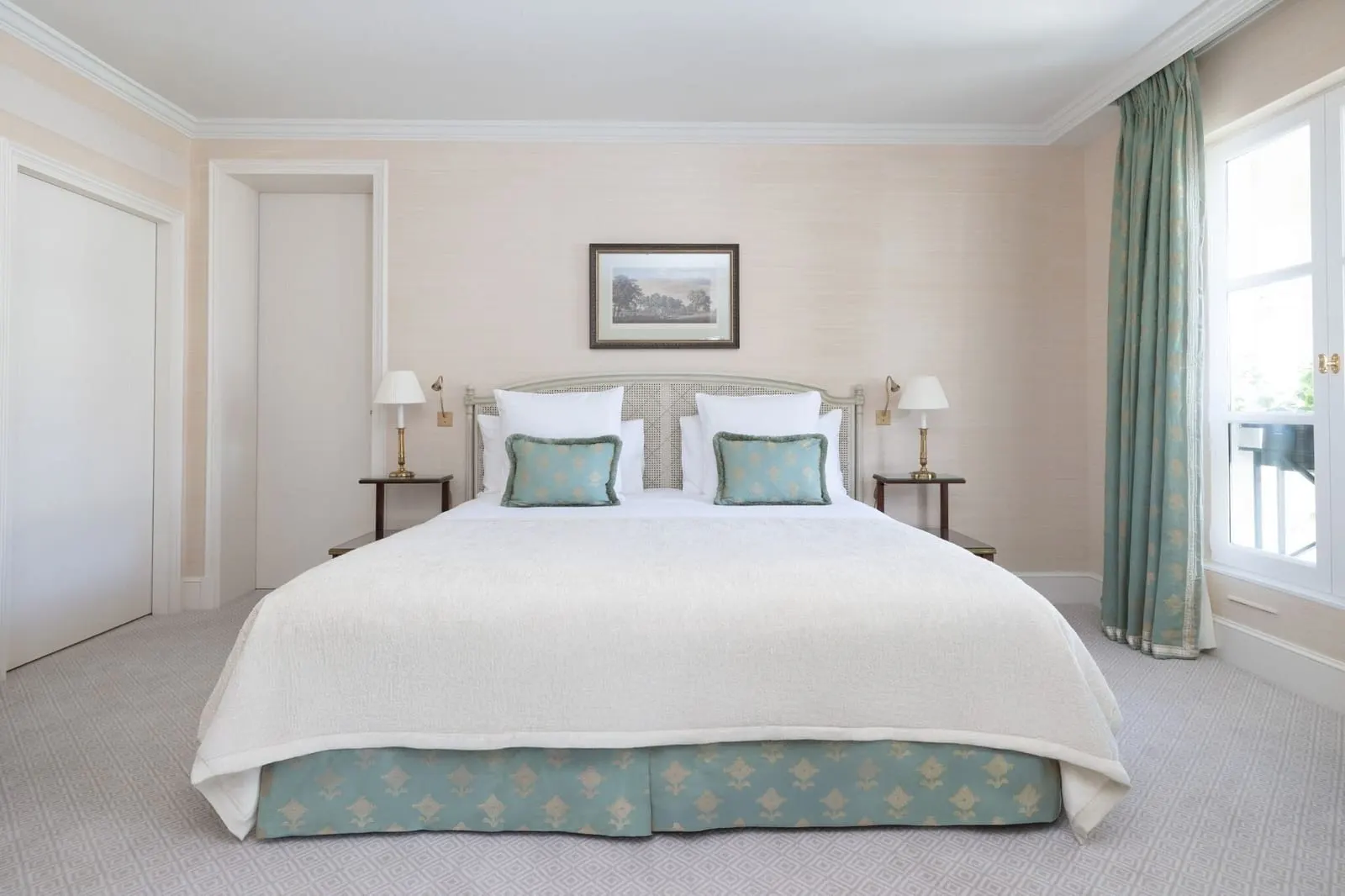 Suite Eden at Le Bristol Paris: a bed with a white cover and pale green cushions against a pale pink wall, between two bedside tables