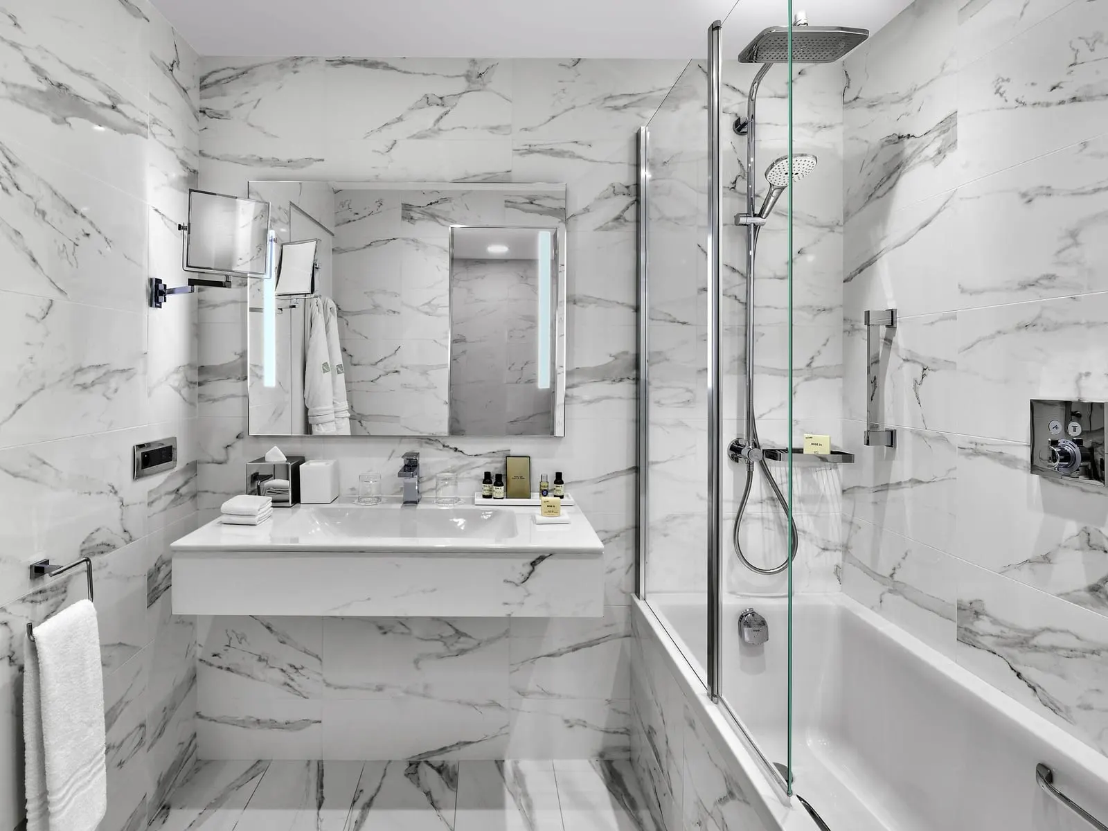 Signature Sea View room at Fairmont Monte Carlo: the marble bathroom with a basin and a bathtub with a glass screen