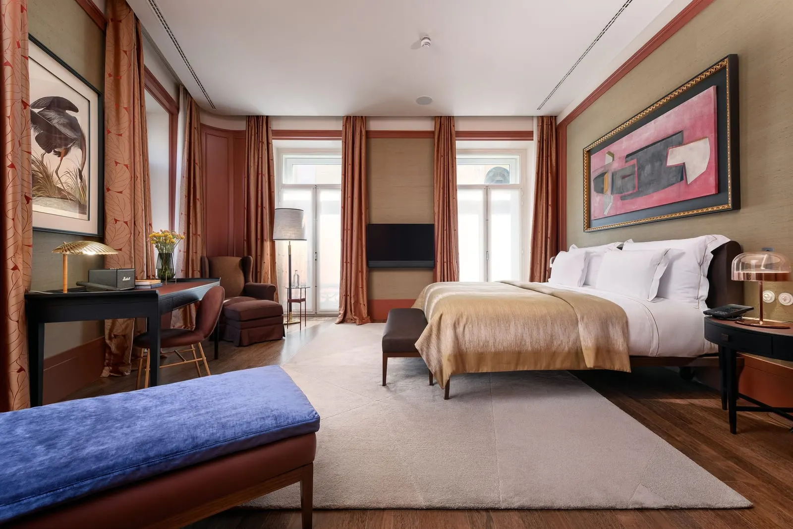 Chiado Suite at Bairro Alto Hotel: the bedroom, with a desk, an armchair, a blue bench and tall French windows
