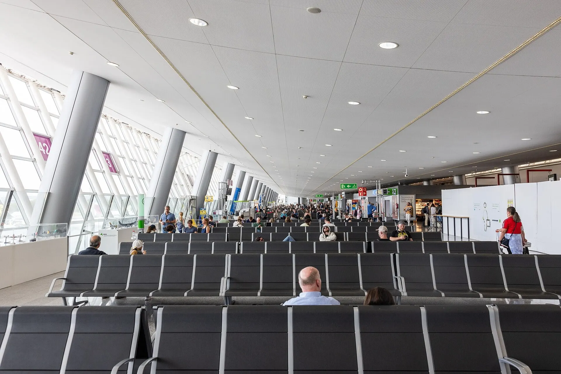 The glass-walled gate lounge at Palma de Mallorca Airport, with rows of seats