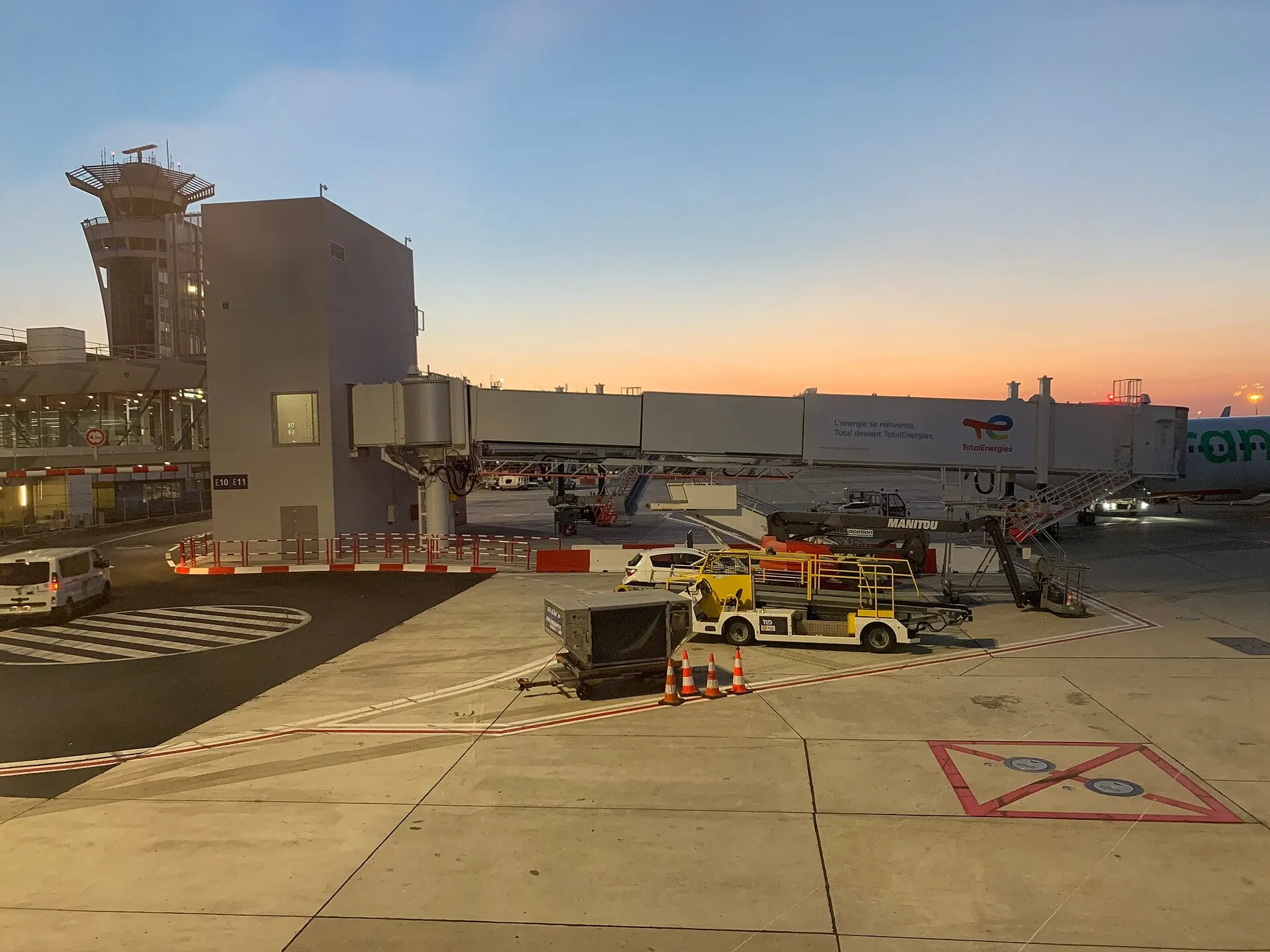 Jet bridges and ground equipment on the apron at Paris Orly at sunset