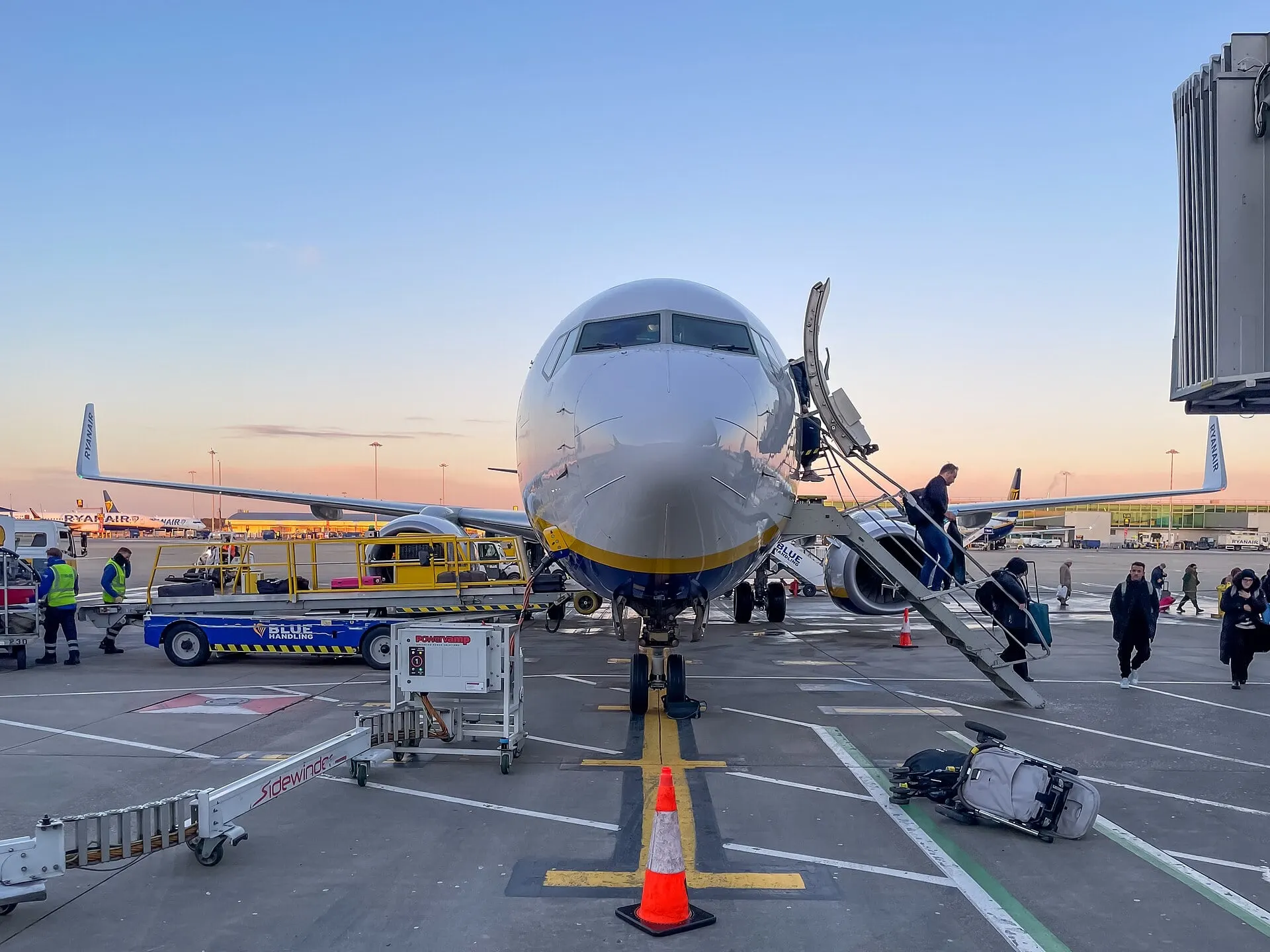 Passengers boarding a Boeing 737 by the steps on the apron at Stansted Airport