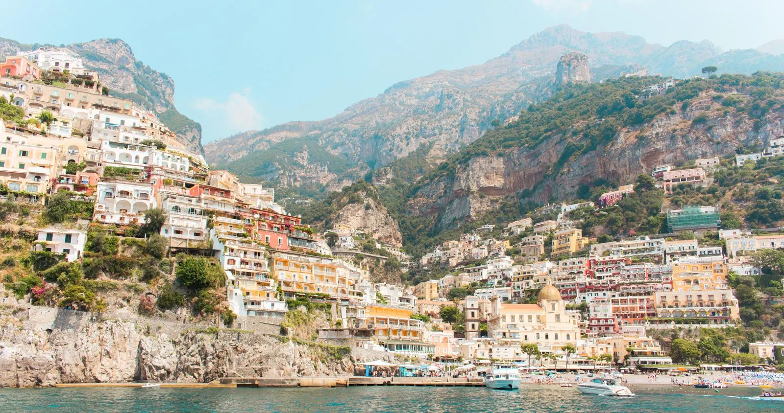 Positano's houses climbing the hillside above the beach, seen from the sea