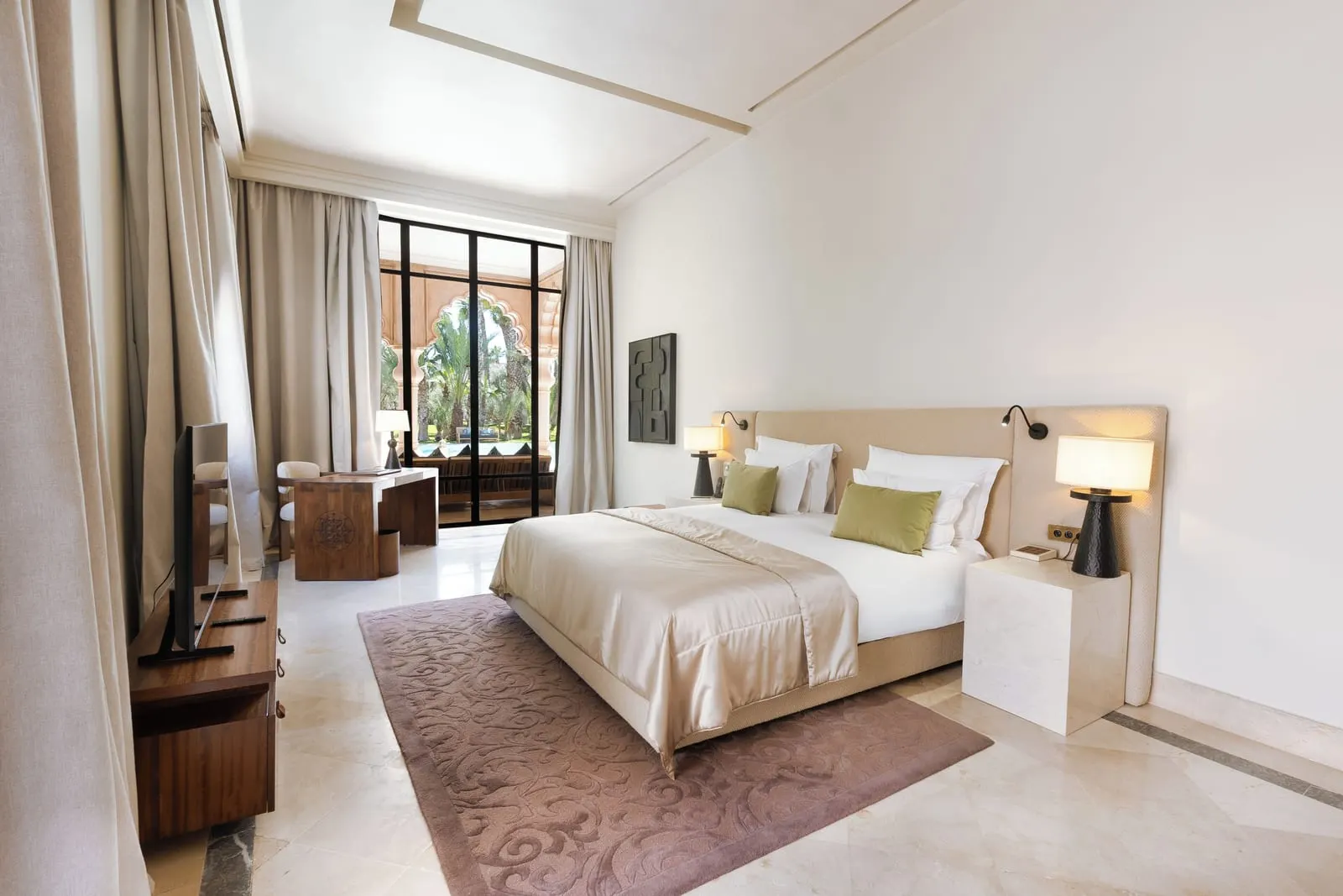 Water Palace at Palais Namaskar: a bright bedroom with a cream bed, a patterned rug and tall windows onto the garden