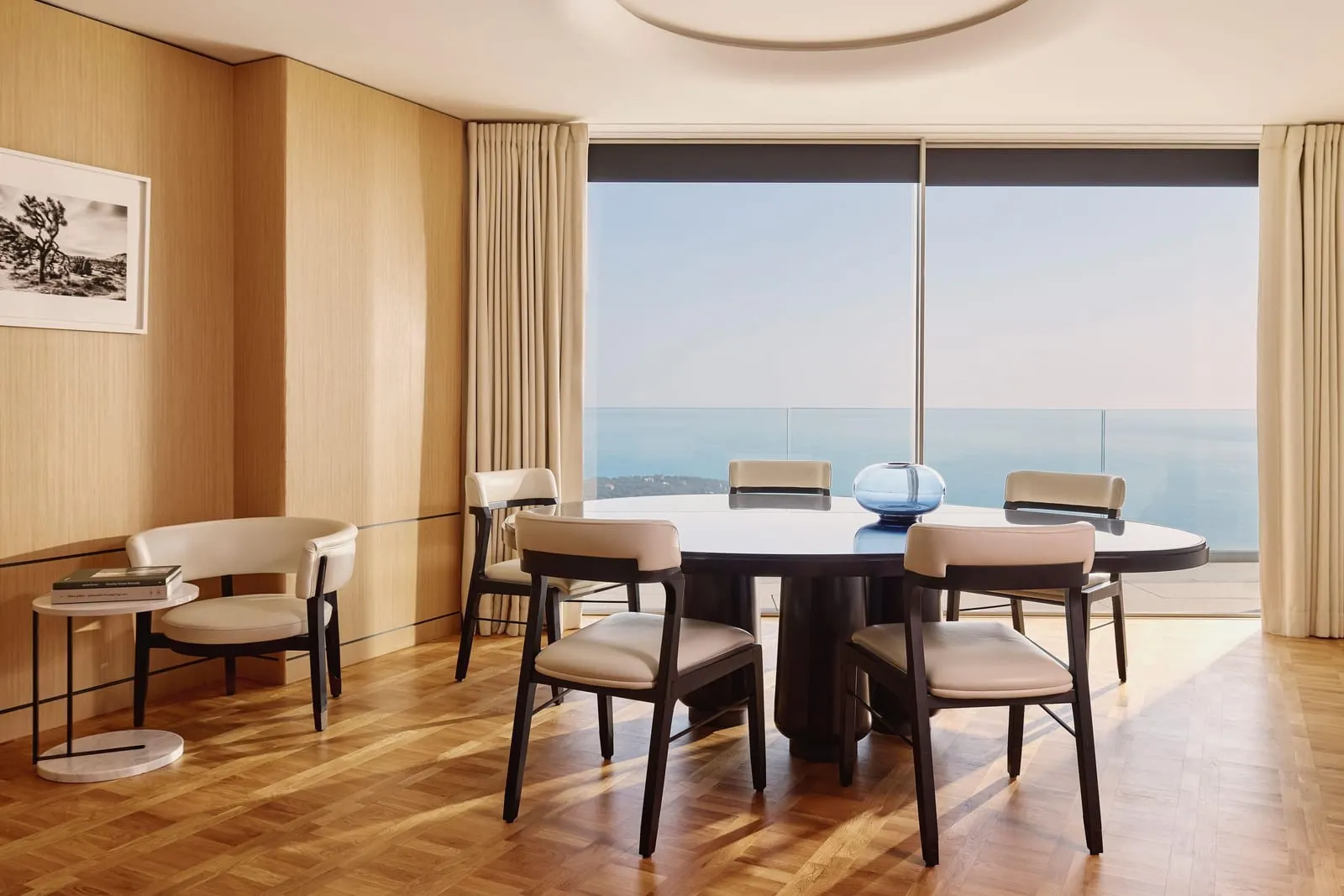The Horizon Suite at The Maybourne Riviera: the dining room with a round table and chairs before a window onto the sea