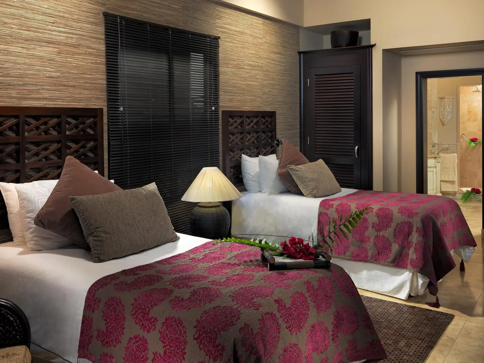 Royal Princess Villa at Royal Garden Villas: a twin bedroom with red bedspreads and a door through to the bathroom