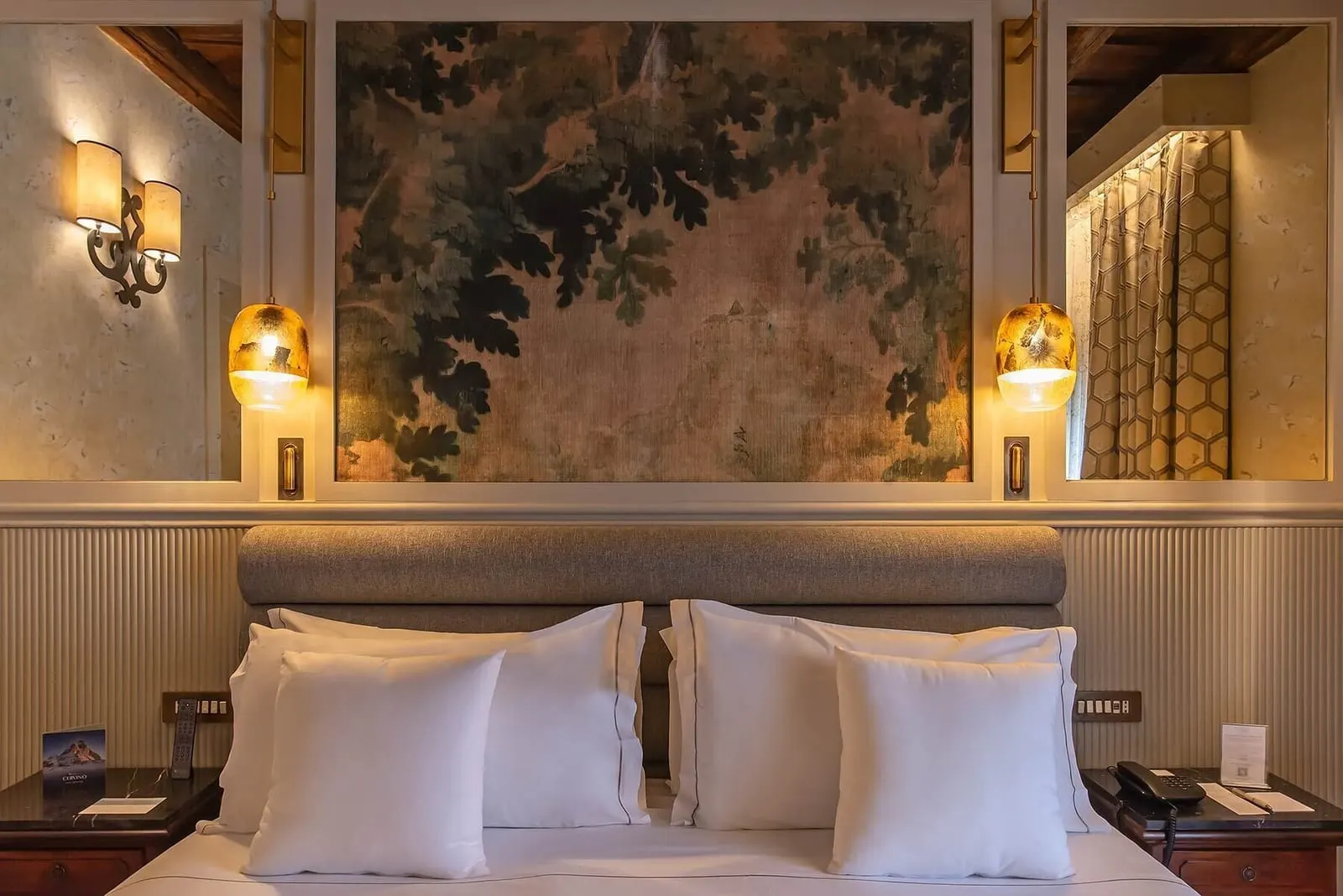 Prestige Deluxe Savelli at Donna Camilla Savelli: the bed under a painted panel of leaves and branches