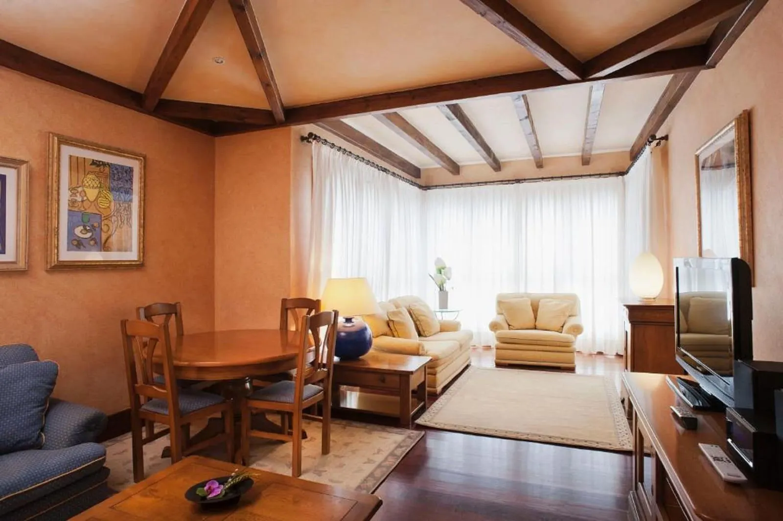 Presidential Suite at Princesa Yaiza Suite Hotel Resort: a living room with a dining table, sofas and a corner of tall windows