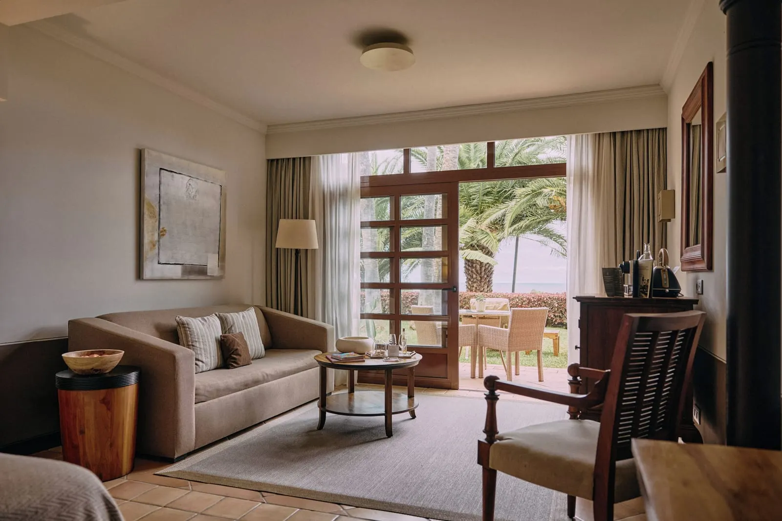 Singular Junior Suite with Garden at Hacienda del Conde: a sofa, an armchair and doors open to the terrace and palms