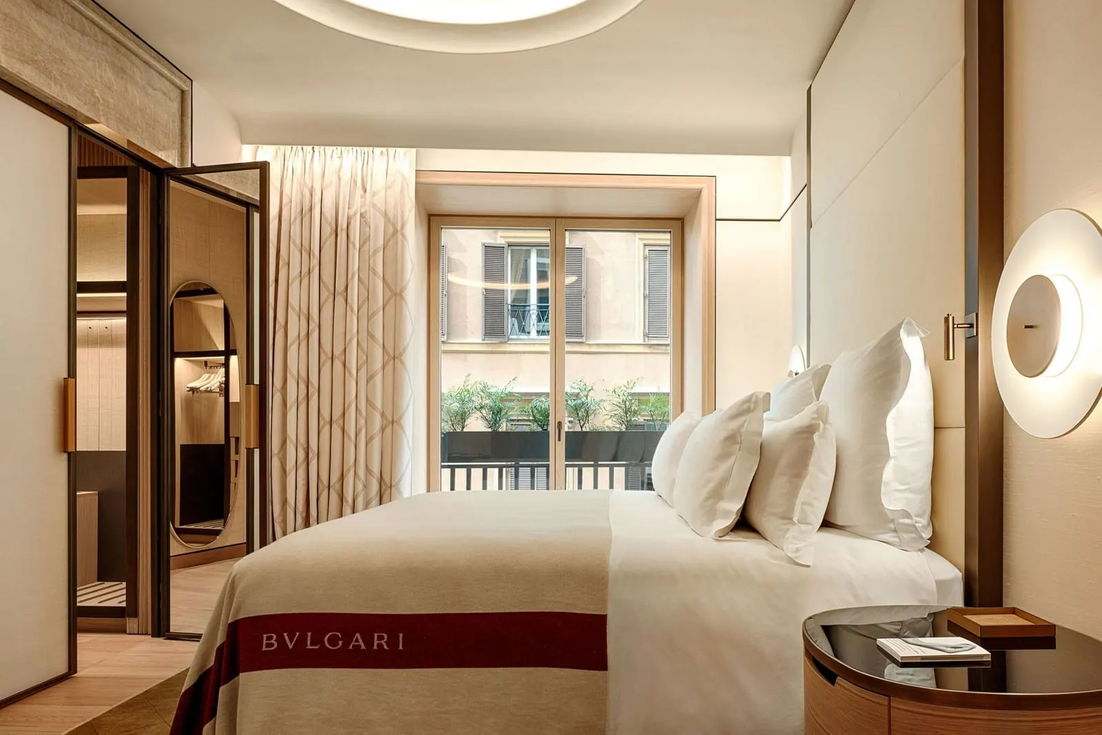 Superior Suite at Bvlgari Hotel Roma: a double bed facing a tall window, with a dressing area on the left