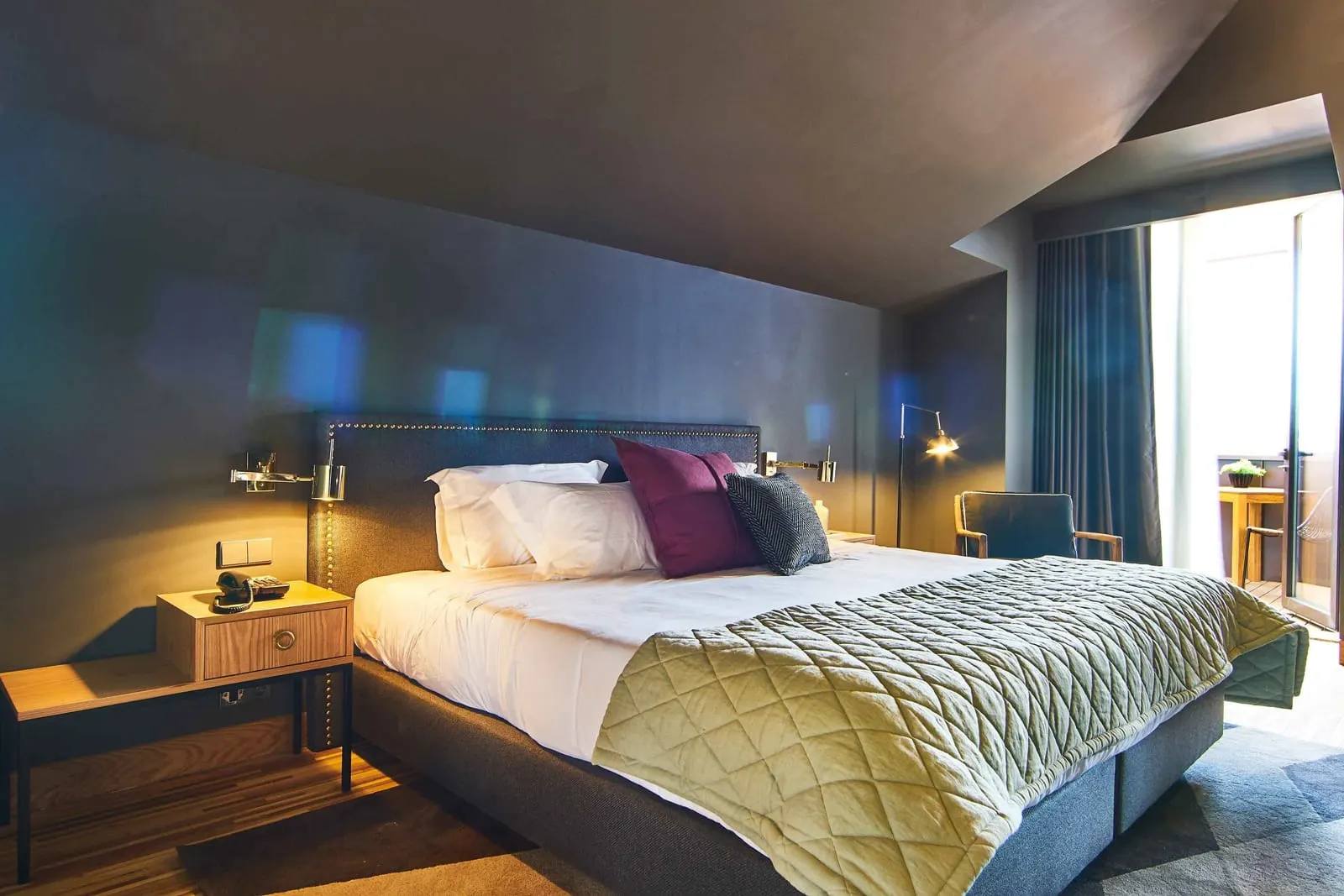 Executive Deluxe Room at Torel Avantgarde: the bed against a padded headboard, with a glass door to the balcony