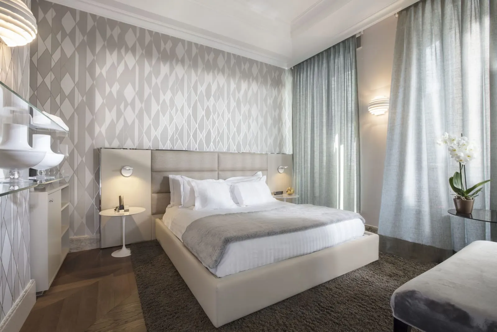 Prestige Room at Palazzo Manfredi: a double bed, patterned grey wallpaper and sheer curtains