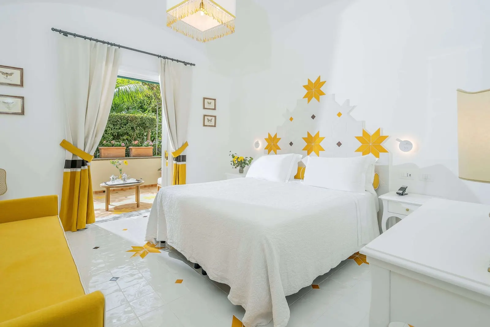 Classic Garden and City view at Palazzo Murat: a double bed under yellow star tiles, with curtained doors open onto a terrace