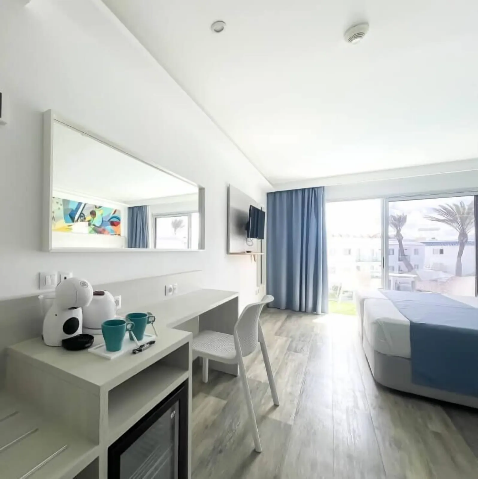 Sky Pool（Corralejo Surfing Colors Hotel & Apartments）：コーヒーマシンとケトルを置いたデスク、ミニ冷蔵庫、テラスへ続くガラス扉のそばのベッド