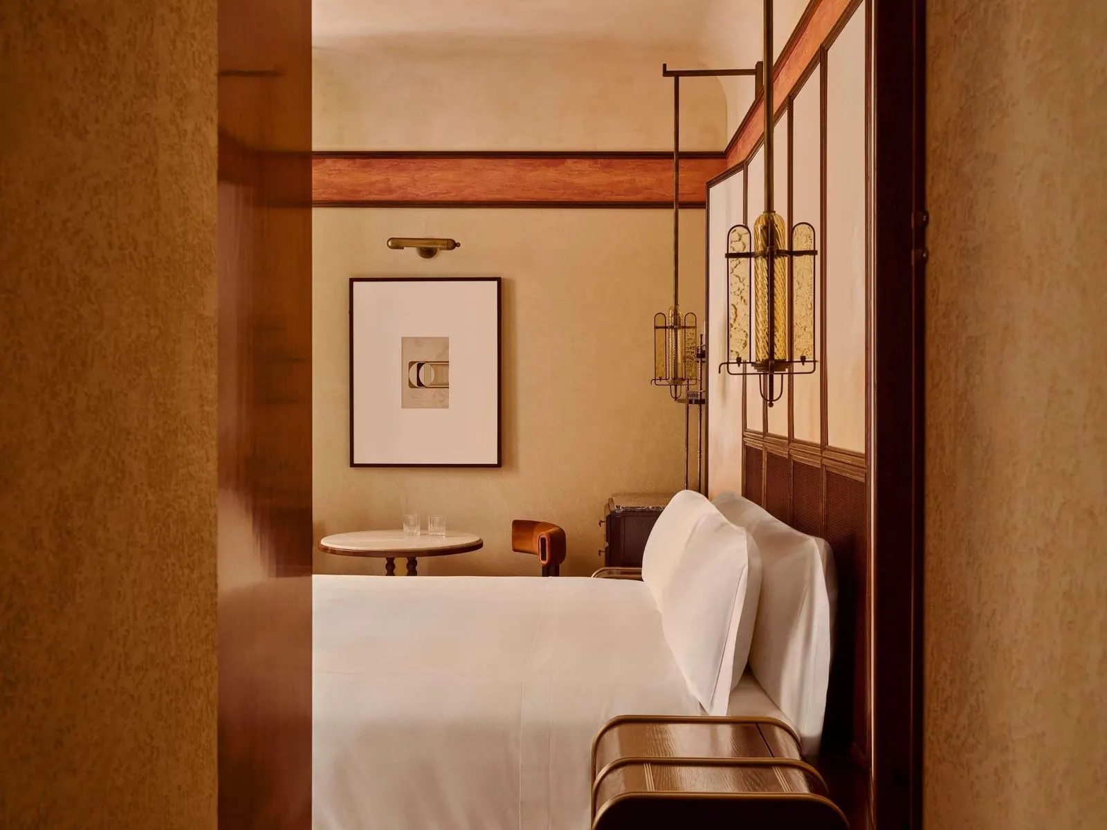 Classic Room at Orient Express La Minerva: the bed, a round table and a framed print, seen through the doorway
