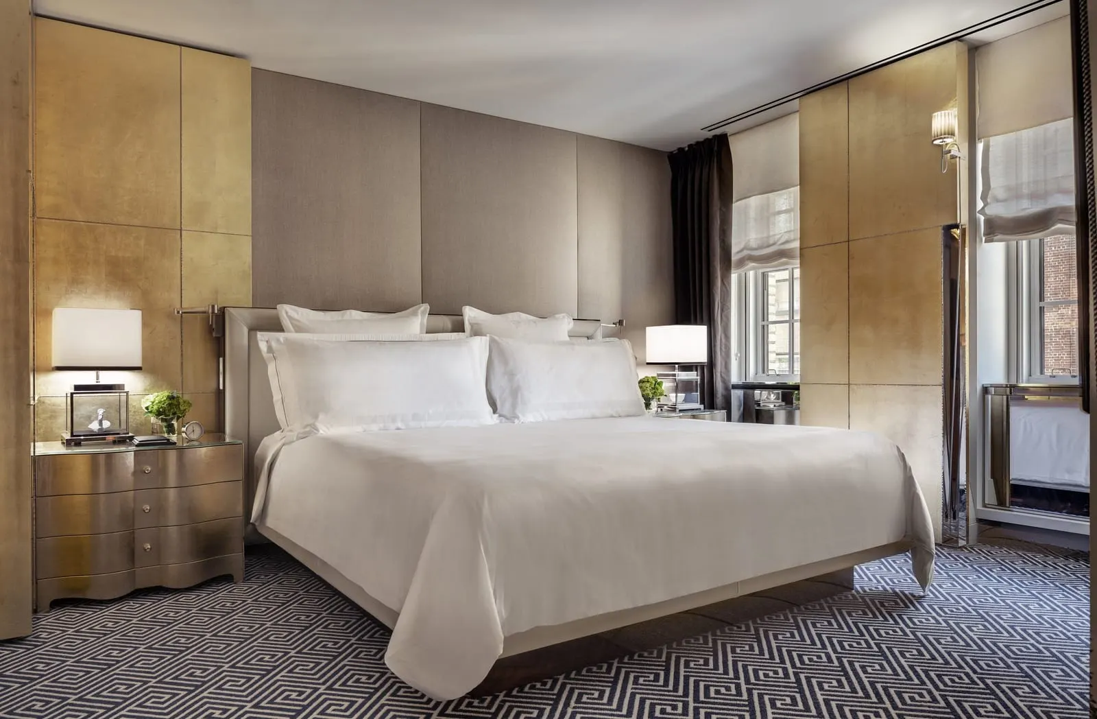 The Carlyle Suite at The Carlyle: a king bed against a padded headboard wall, with gold-leaf panels on either side