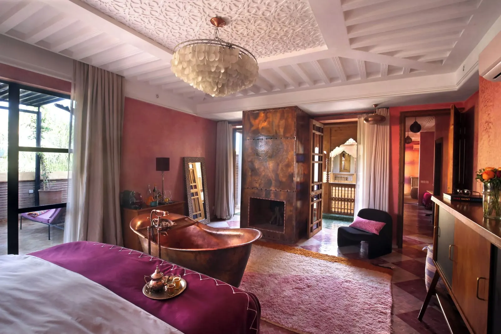 Extra Large Room with Terrace at El Fenn: a copper bath at the foot of the bed, a copper-clad fireplace and a sitting corner