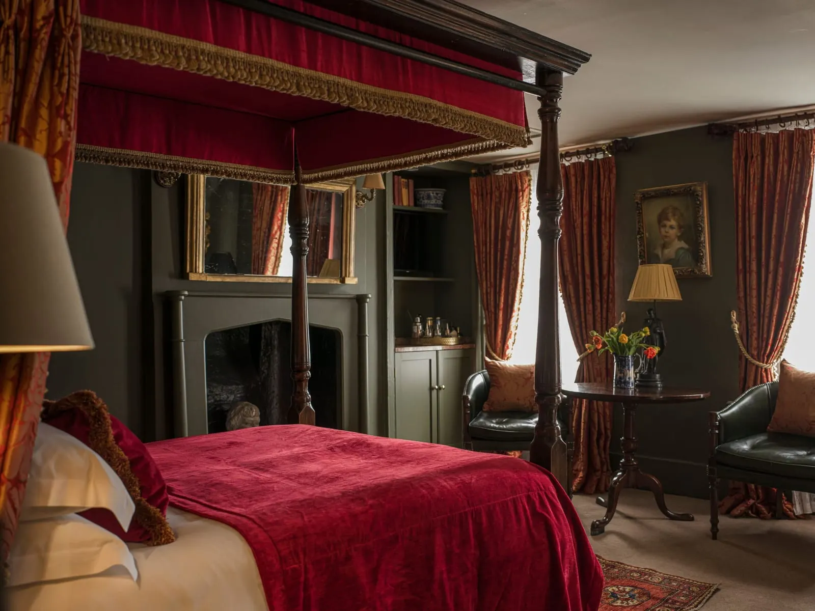 Superior Double at Hazlitt's: a four-poster bed with a red canopy, green walls, a fireplace and two leather armchairs