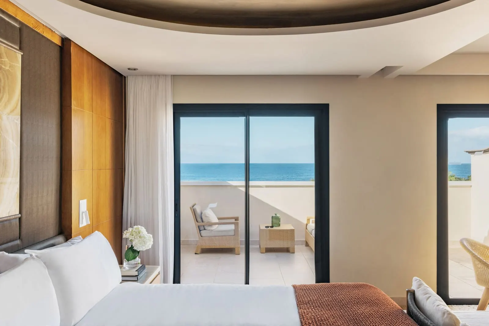 RedLevel Junior Suite Ocean Front at Gran Meliá Palacio de Isora: the bed and a glass door onto the balcony and the sea