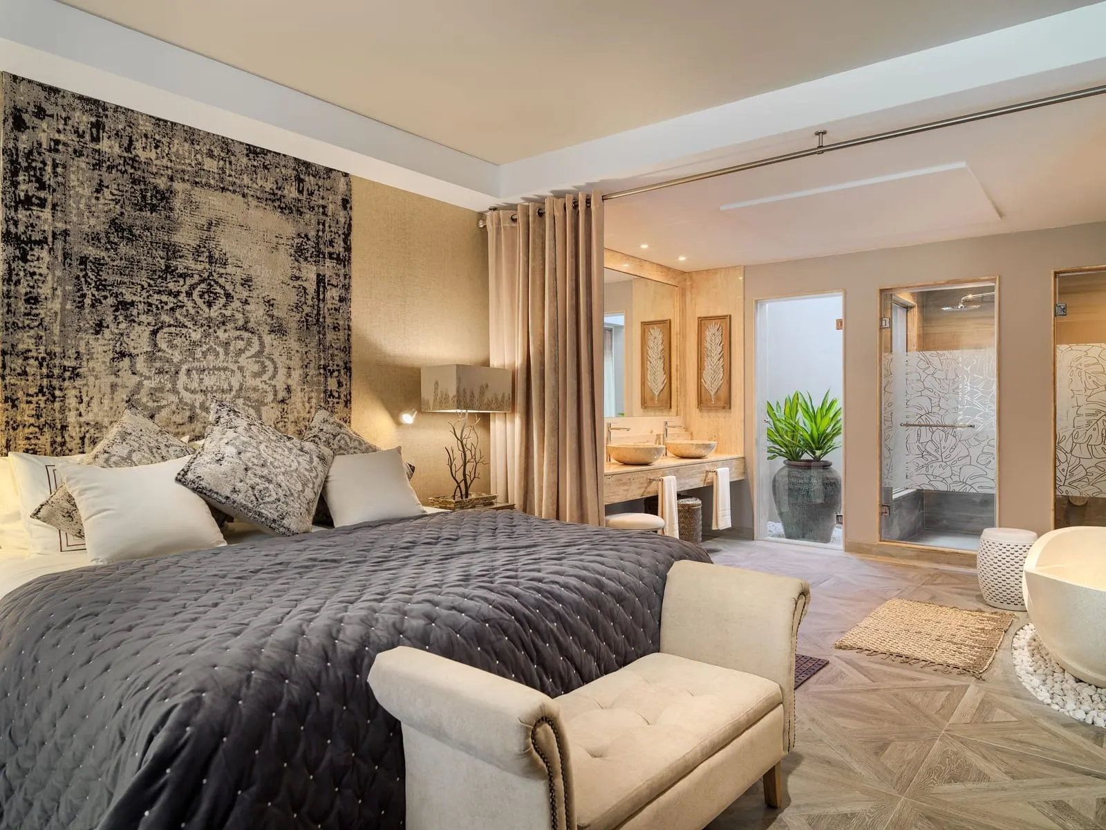 One-bedroom River Villa at Royal River: the bed, a freestanding bath and a glass shower beyond