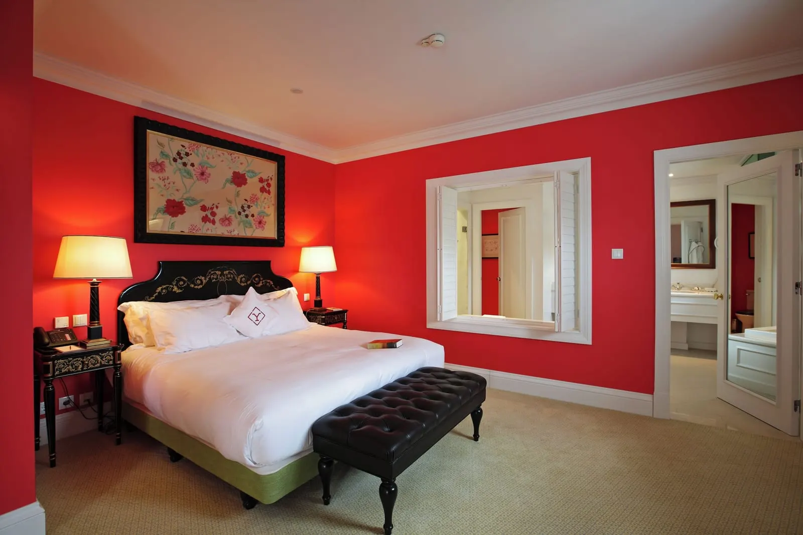 Master Suite Panoramic at The Yeatman: the bed with a leather bench in a red bedroom, and an open door to the bathroom