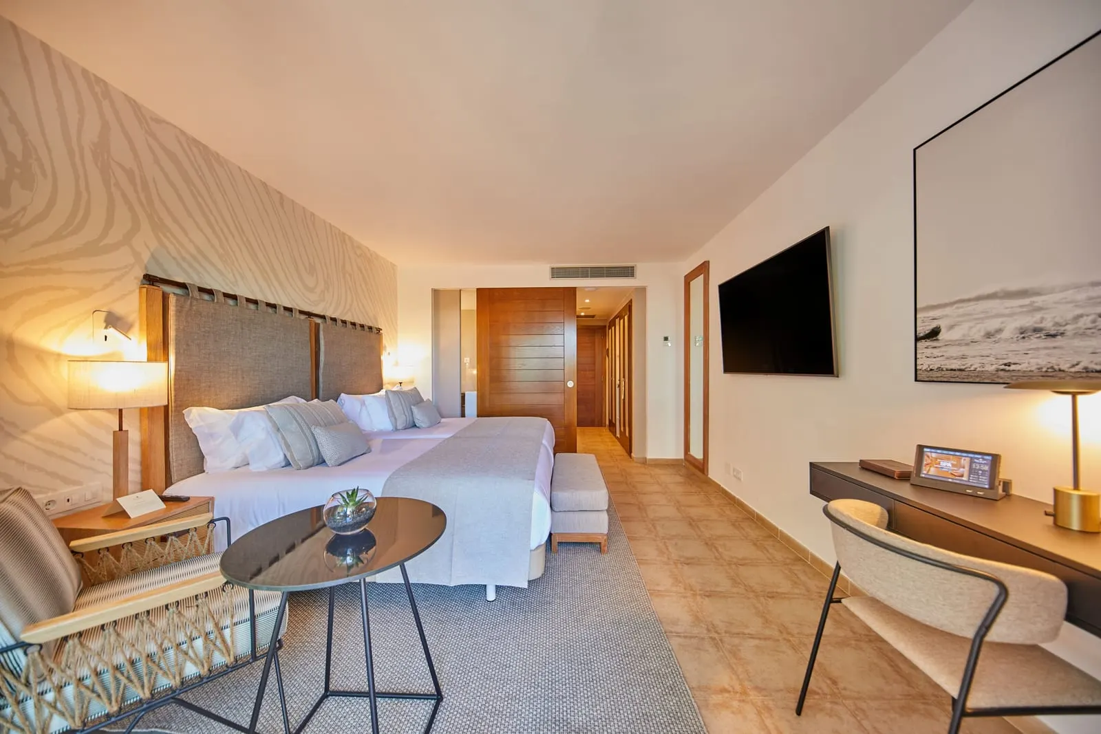Double al Secrets Lanzarote Resort & Spa: una camera con un grande letto, un tavolino da divano, un televisore e una scrivania