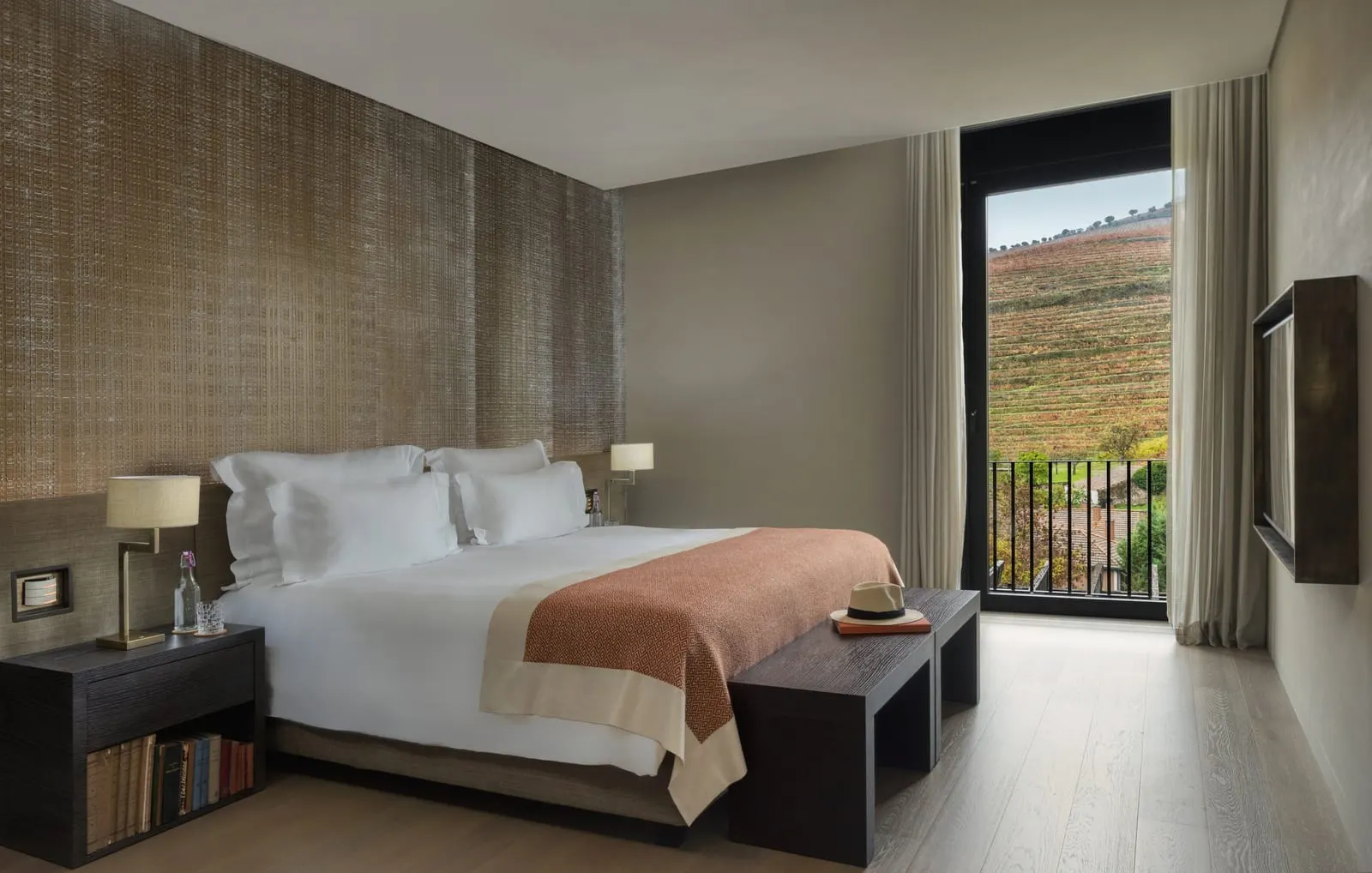 Vineyard Suite at Six Senses Douro Valley: the bed and a door open to a small balcony above terraced vineyards
