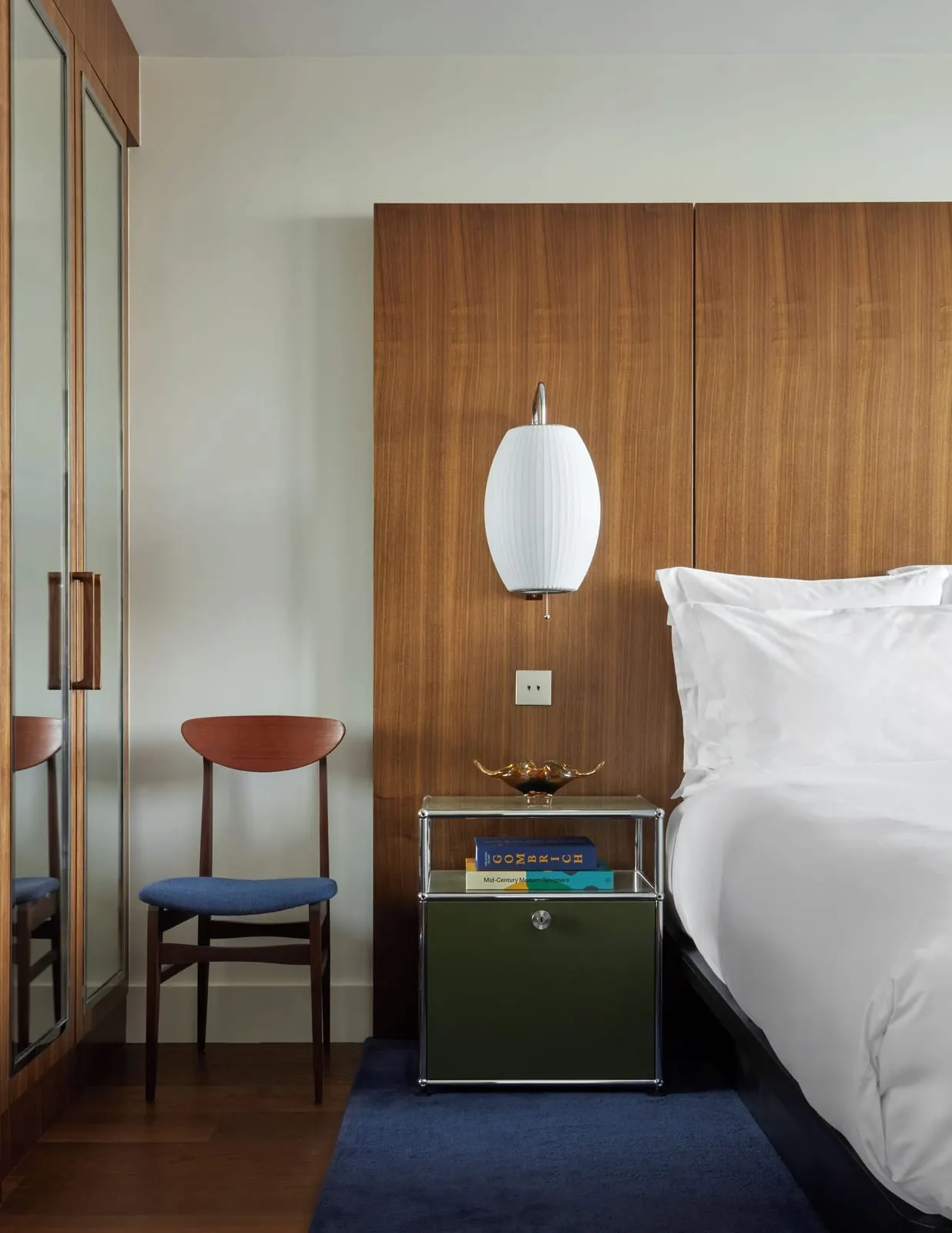 Mid-Century Cabin Suite at Sea Containers London: the bed against a wood-panelled wall, a paper lamp and a blue chair