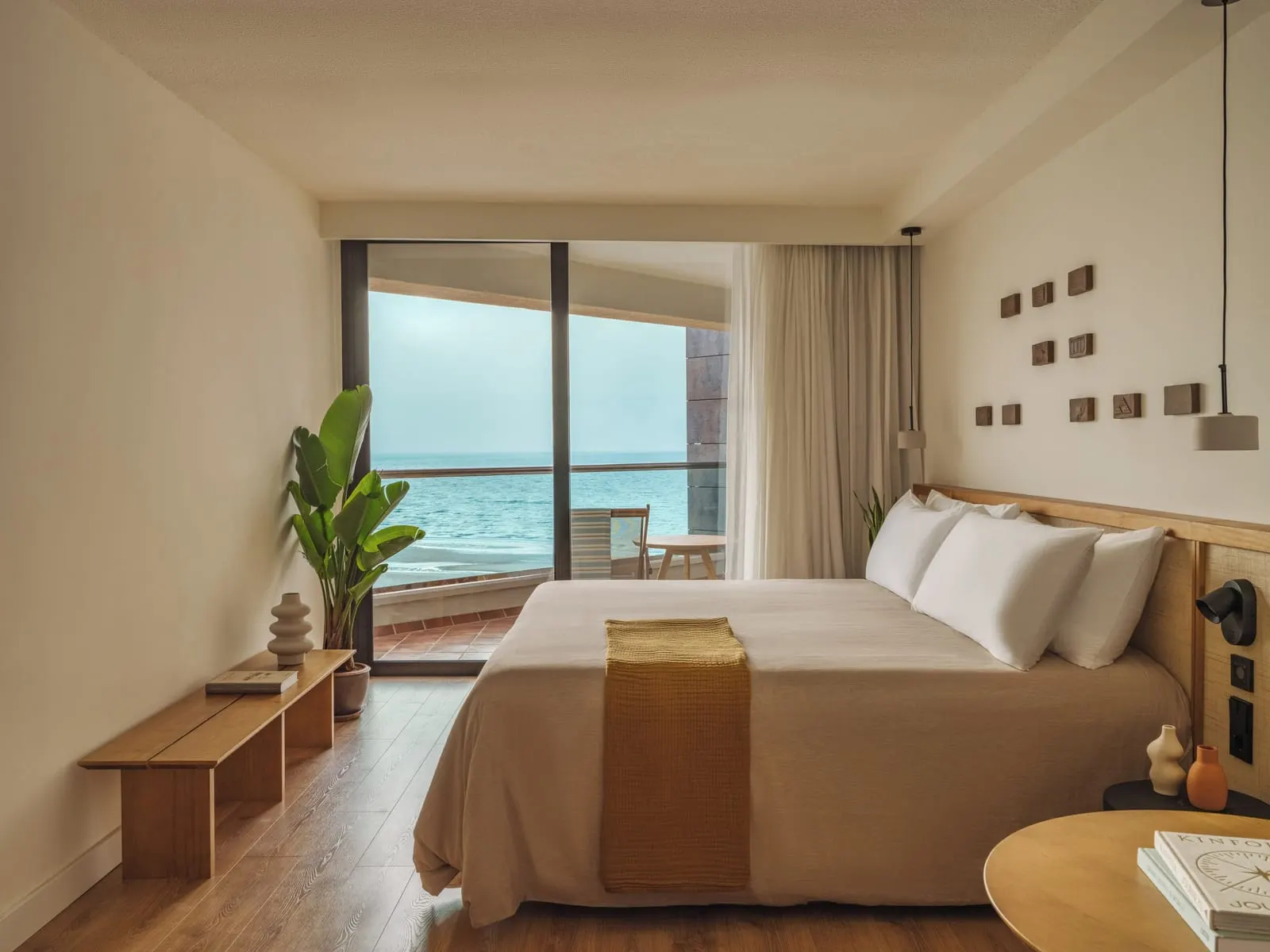 The Reserve Premium Room Ocean Front at Paradisus by Meliá Fuerteventura: a king-size bed and a bench facing a glass door to a terrace over the sea