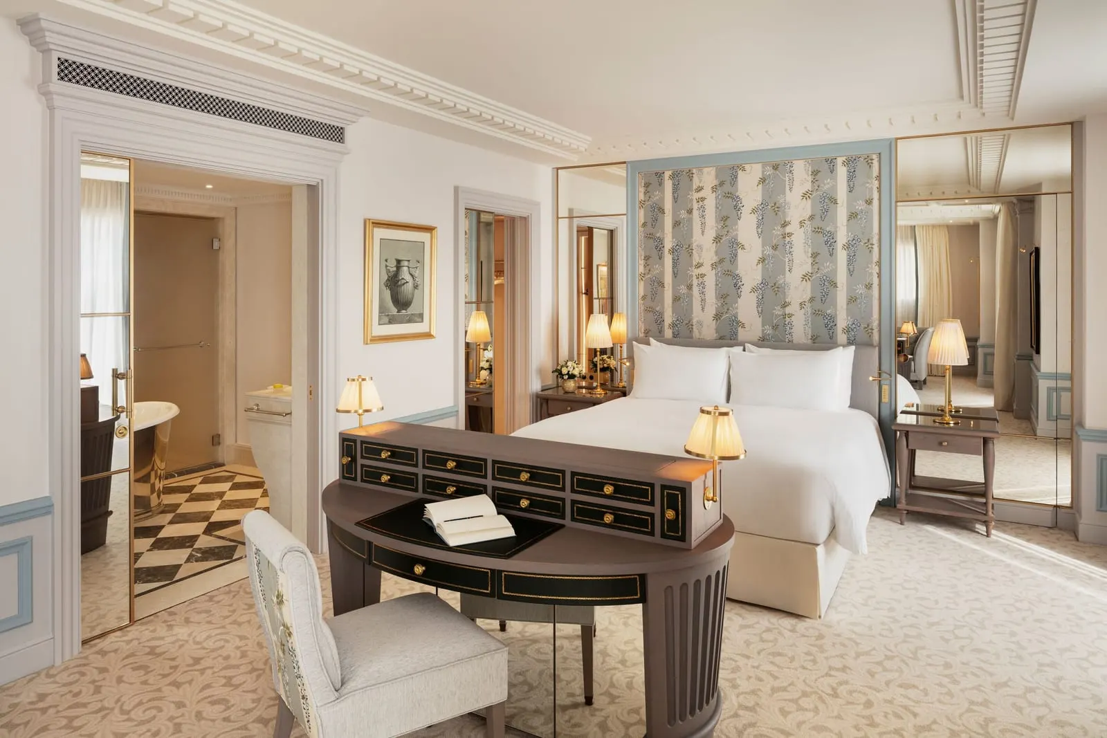 Prestige Junior Suite at Hôtel Métropole Monte-Carlo: the bed behind a desk, with the bathroom through a doorway