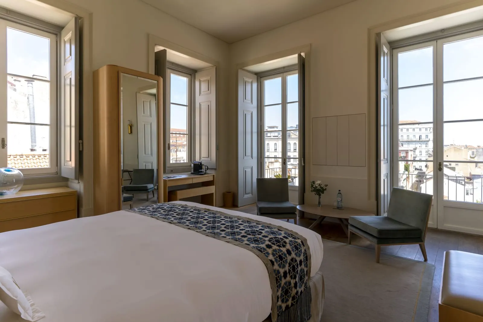 Superior Room with River View at Verride Palácio Santa Catarina: the bed, two armchairs and tall windows on two walls