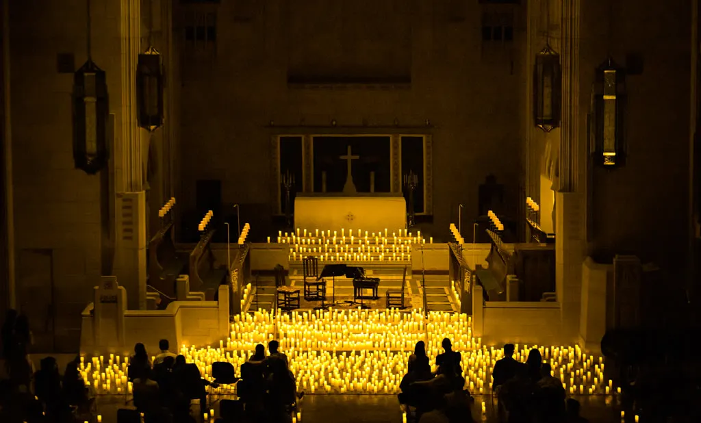 Church of the Heavenly Restの後方から、観客とキャンドルの向こうのステージを望む眺め