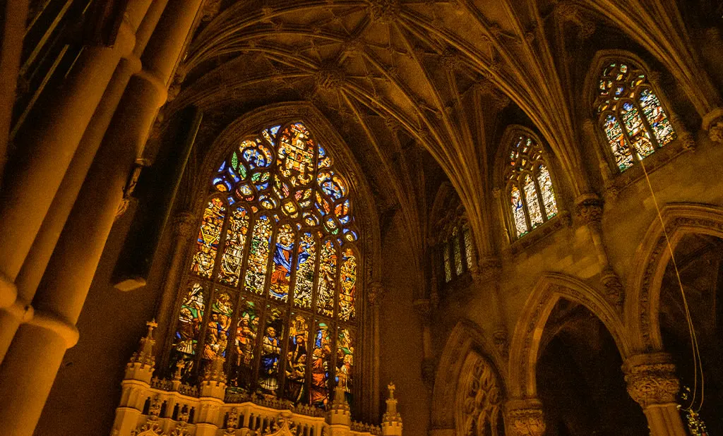 The stained-glass windows and vaulted ceiling of St. Ann & the Holy Trinity Church, lit warm for a concert