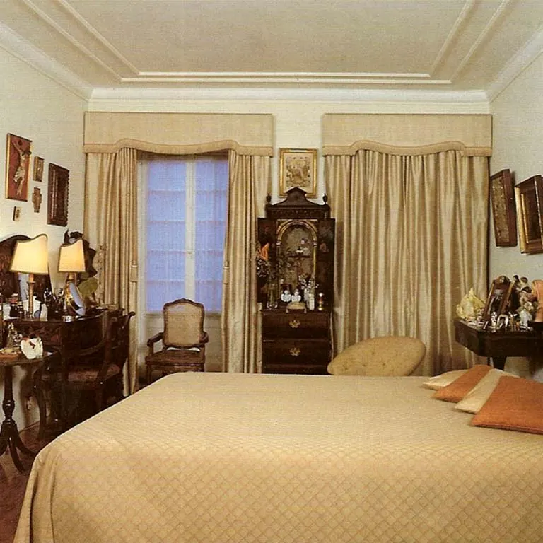 Amália Rodrigues's bedroom in the house on Rua de São Bento, with a large bed, a writing desk, lamps and curtained windows