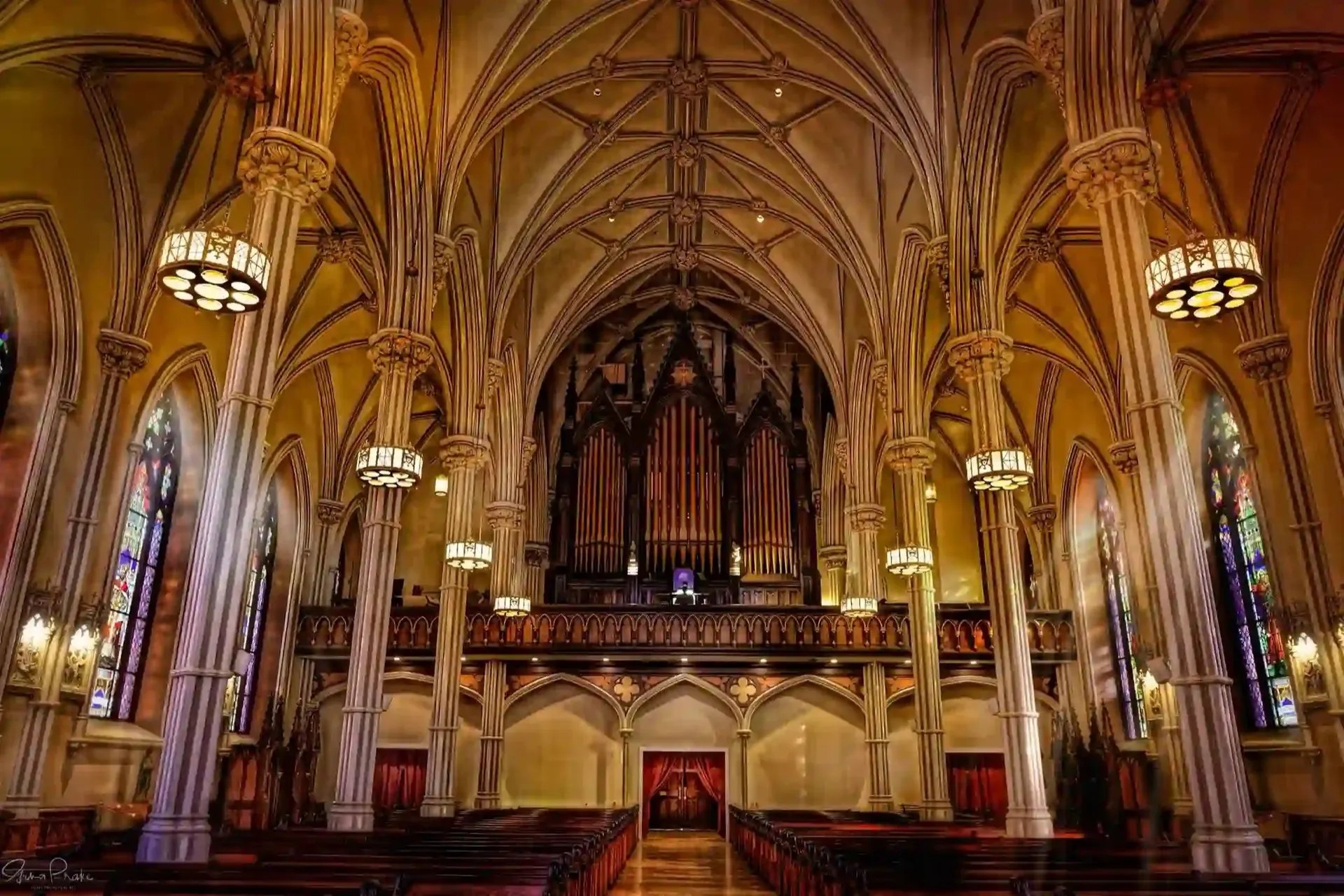 吊りランタンの下に広がるThe Basilica of St. Patrick's Old Cathedralの身廊。聖歌隊席のパイプオルガンの方向を望む