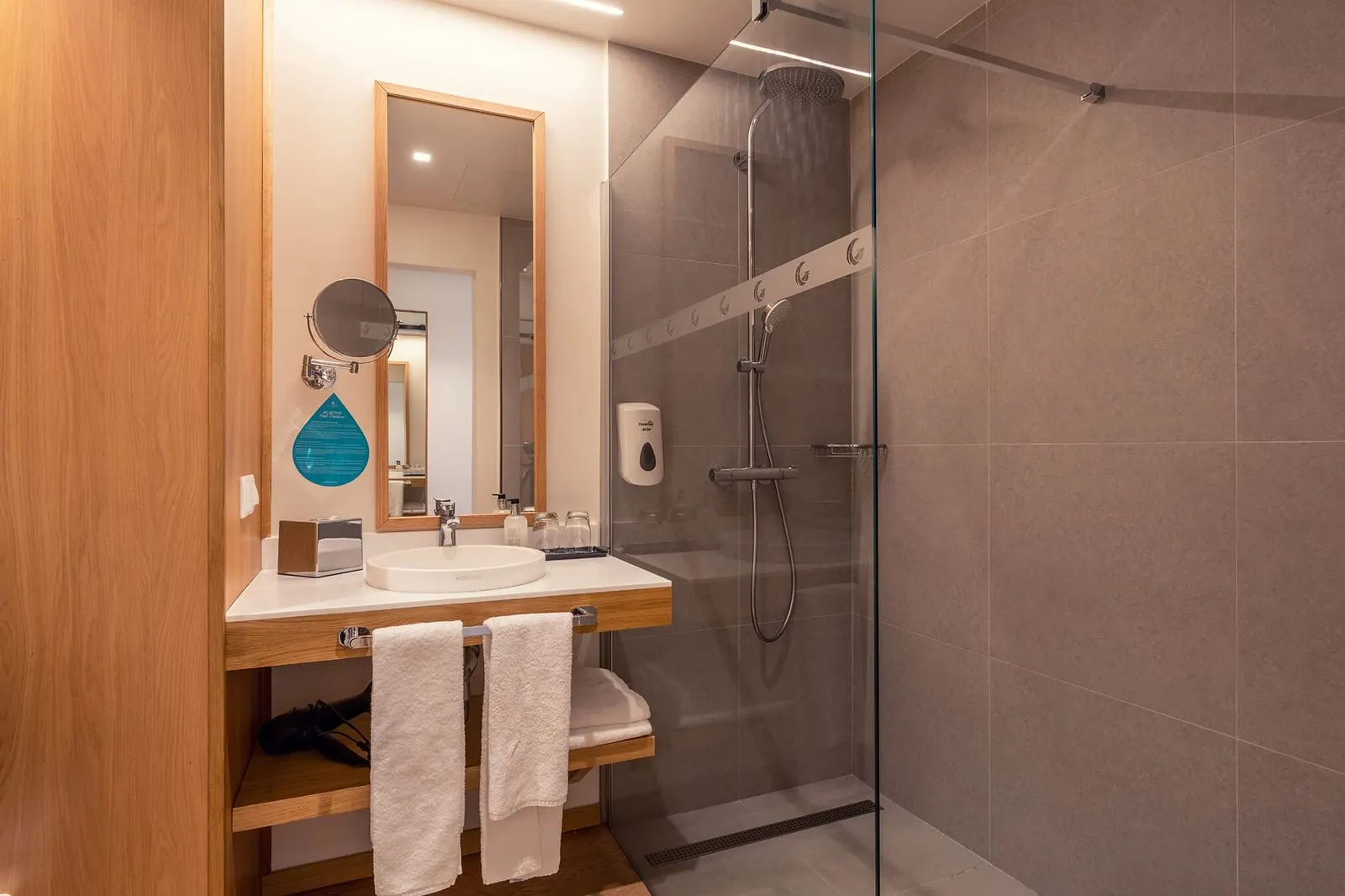 Double Room Side Sea View Balcony at Sentido Galomar: a bathroom with a basin on a wooden shelf, a tall mirror and a walk-in glass shower
