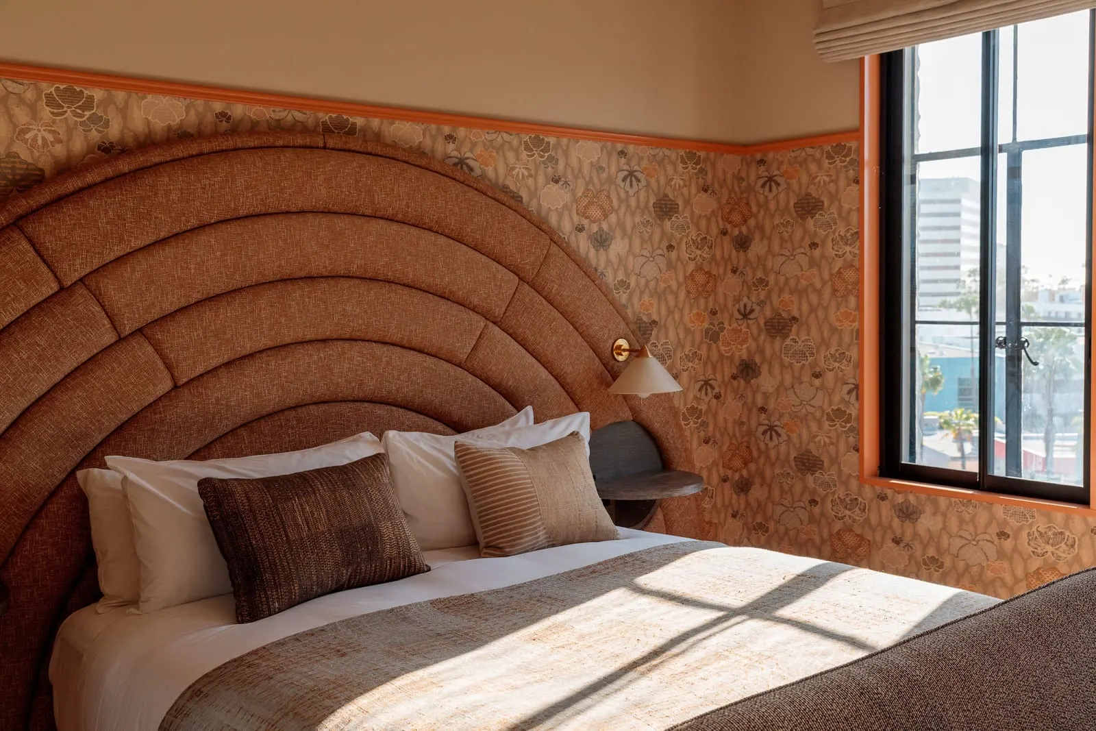 Landmark Premier King im Santa Monica Proper Hotel: ein Bett vor einem hohen bogenförmigen Kopfteil, mit geblümter Tapete, einer Wandlampe und einem Fenster daneben