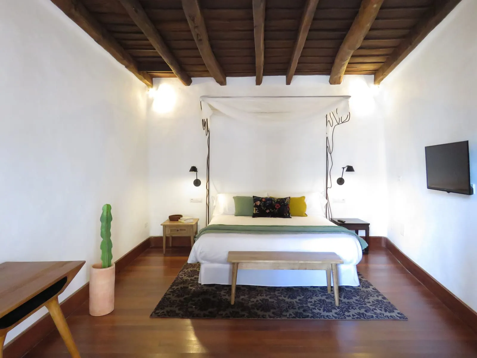 Room 02 at Hotel Boutique Palacio Ico: a double bed with a white canopy under a dark wooden beamed ceiling