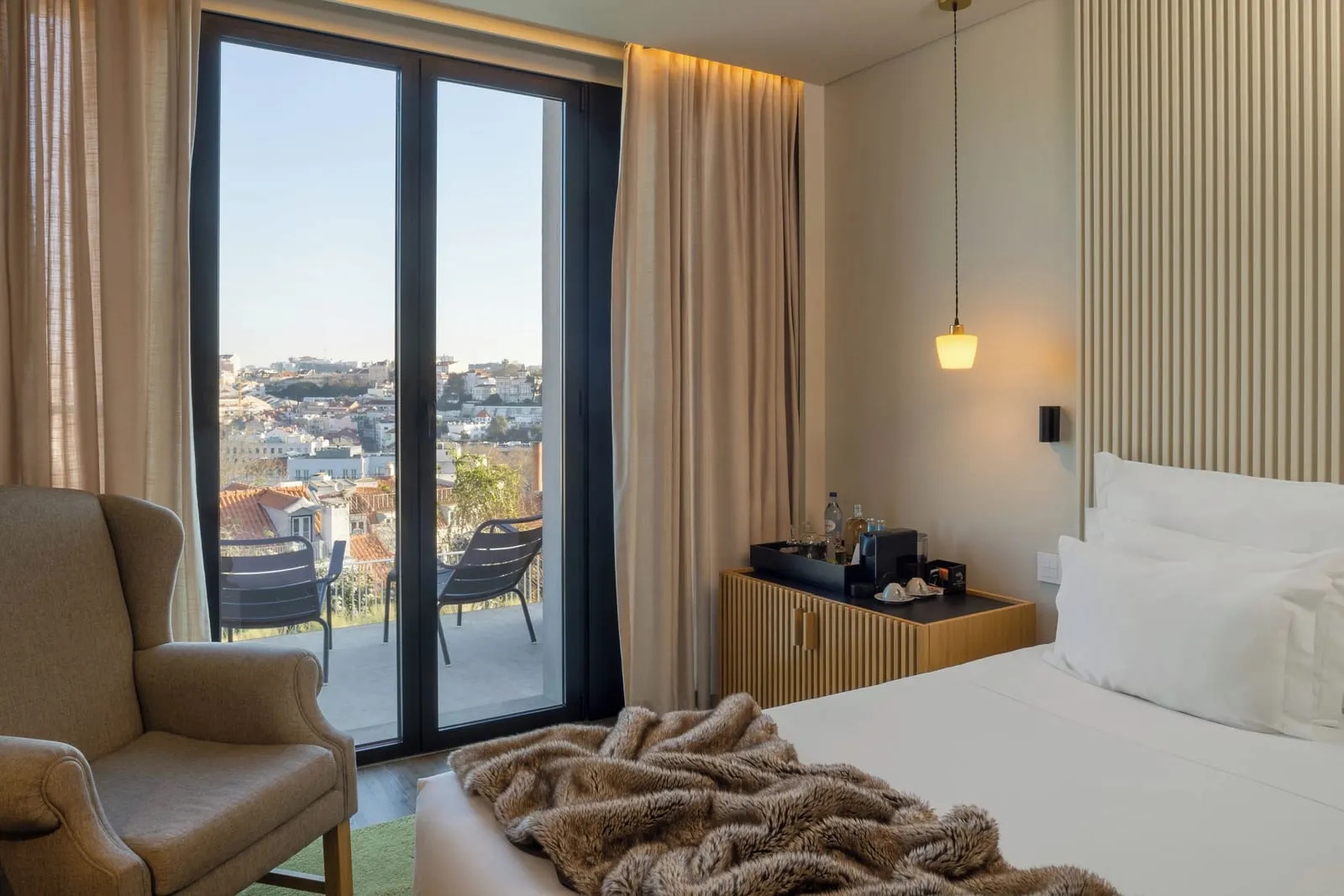 Superior Terrace City View Room at Memmo Príncipe Real: glass doors to a terrace with two lounge chairs and the city beyond