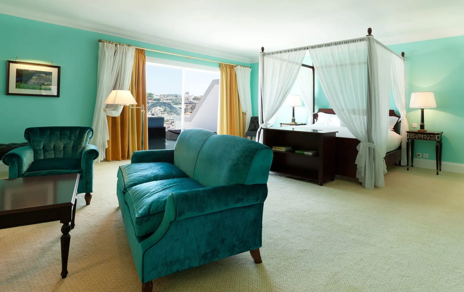 Suite Deluxe Panoramic at The Yeatman: a teal sofa and armchair, and a four-poster bed with white drapes by the window