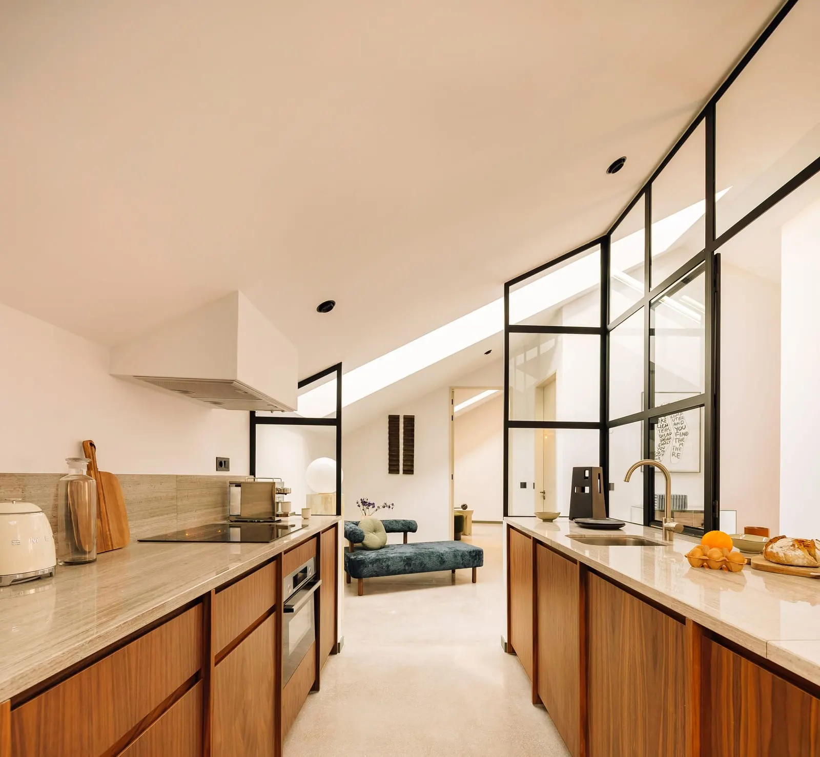 One Bedroom River Suite at The Rebello: the galley kitchen, with a glass-walled room under the sloping ceiling beyond