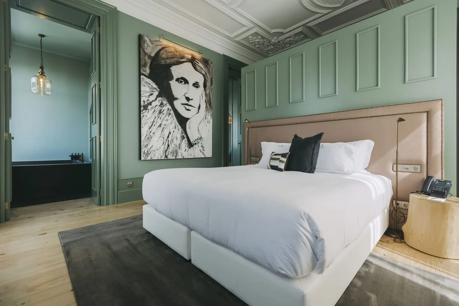 Royal Suite at Torel Avantgarde: the bed below a large portrait, with panelled green walls and a moulded ceiling