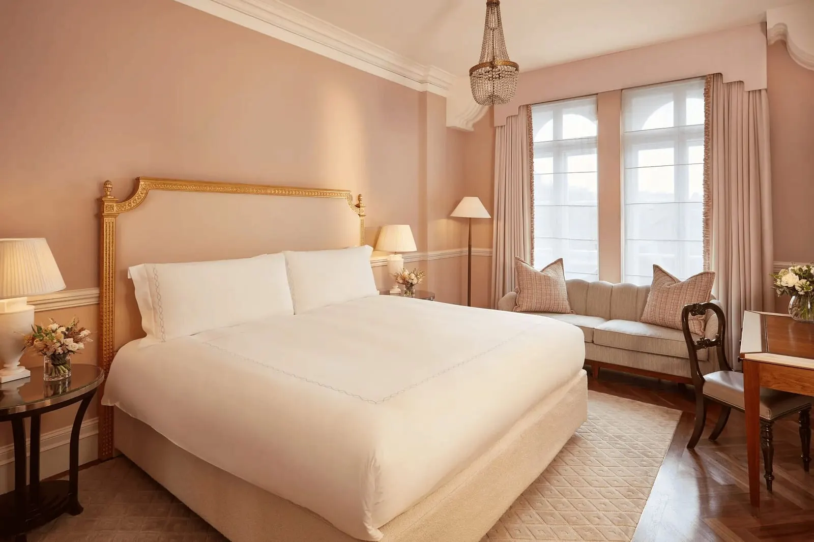 Mayfair Room at Claridge's: the bed with a gilded headboard, pink walls and a cushioned seat under the window