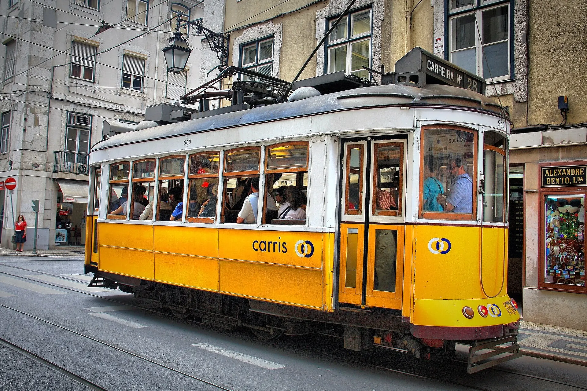 A yellow Carris tram on route 28 climbing a street in central Lisbon